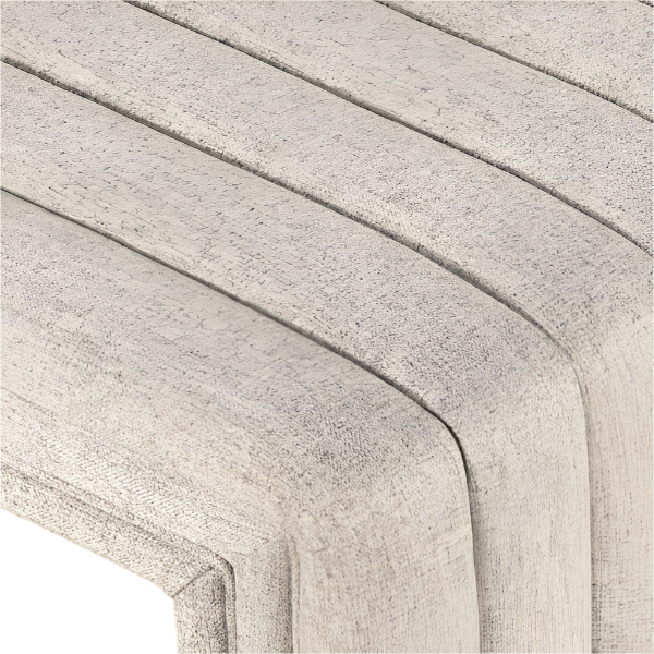 Close-up of a natural beige boucle upholstered bench corner showing rounded channeling, textured fabric surface, and seam detail along the seat edge.
