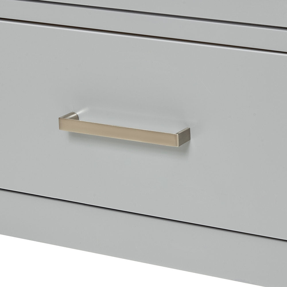 Close-up of a stone-colored wooden vanity drawer front showing a centered rectangular brushed-nickel bar handle and narrow recessed seams above and below the panel.