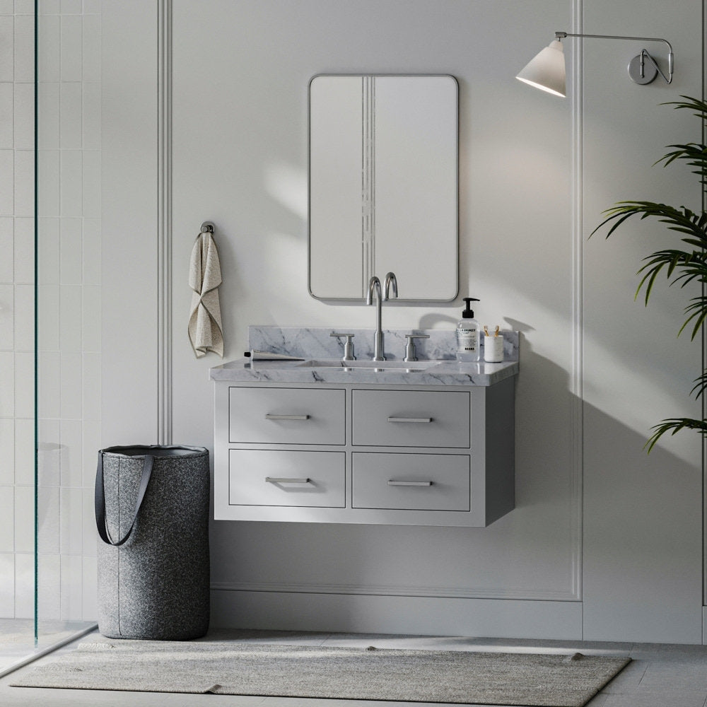 Wall-mounted modern 37-inch solid wood bathroom vanity in stone gray with a stone top and single undermount sink, brushed-nickel faucet, four drawers, rectangular mirror, wall sconce, towel hook and gray felt laundry basket.