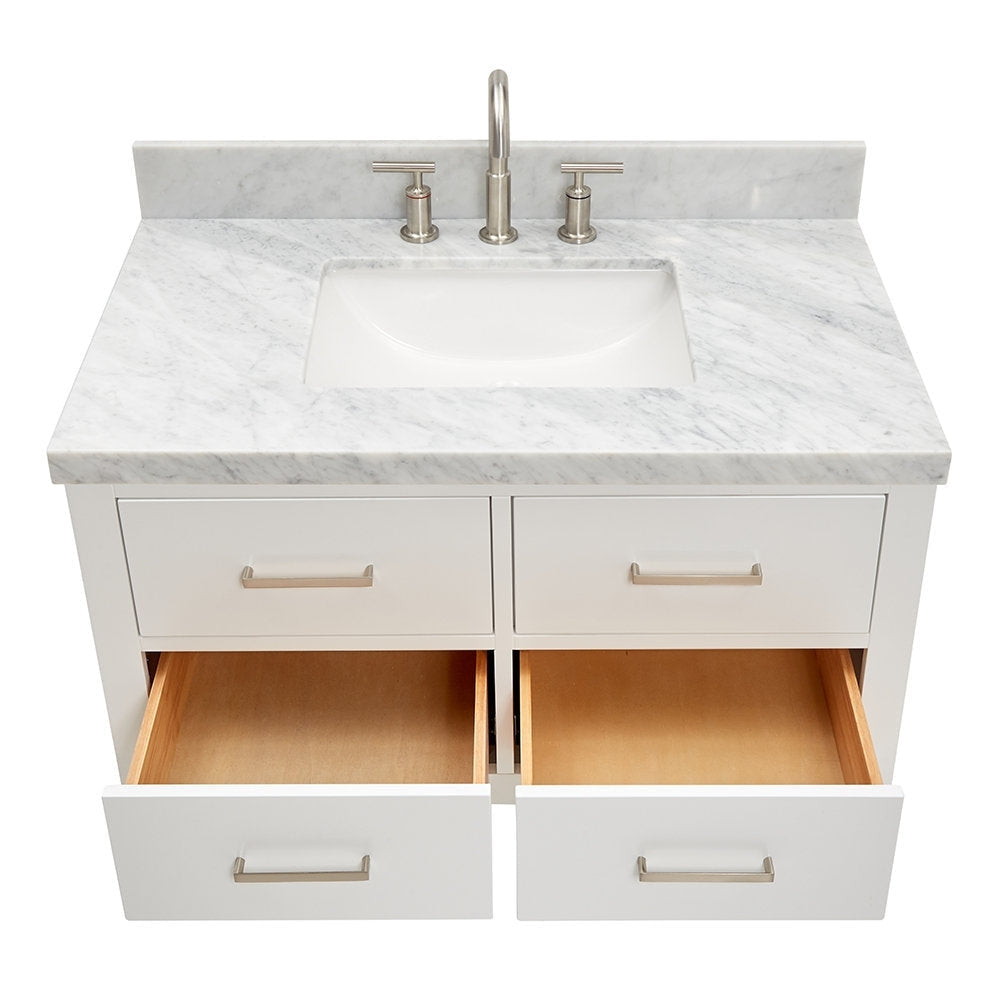 Top-down view of a modern white wooden bathroom vanity with a stone marble top, integrated rectangular ceramic sink, brushed-nickel faucet and handles, and four drawers with the two bottom drawers open showing wood interiors.
