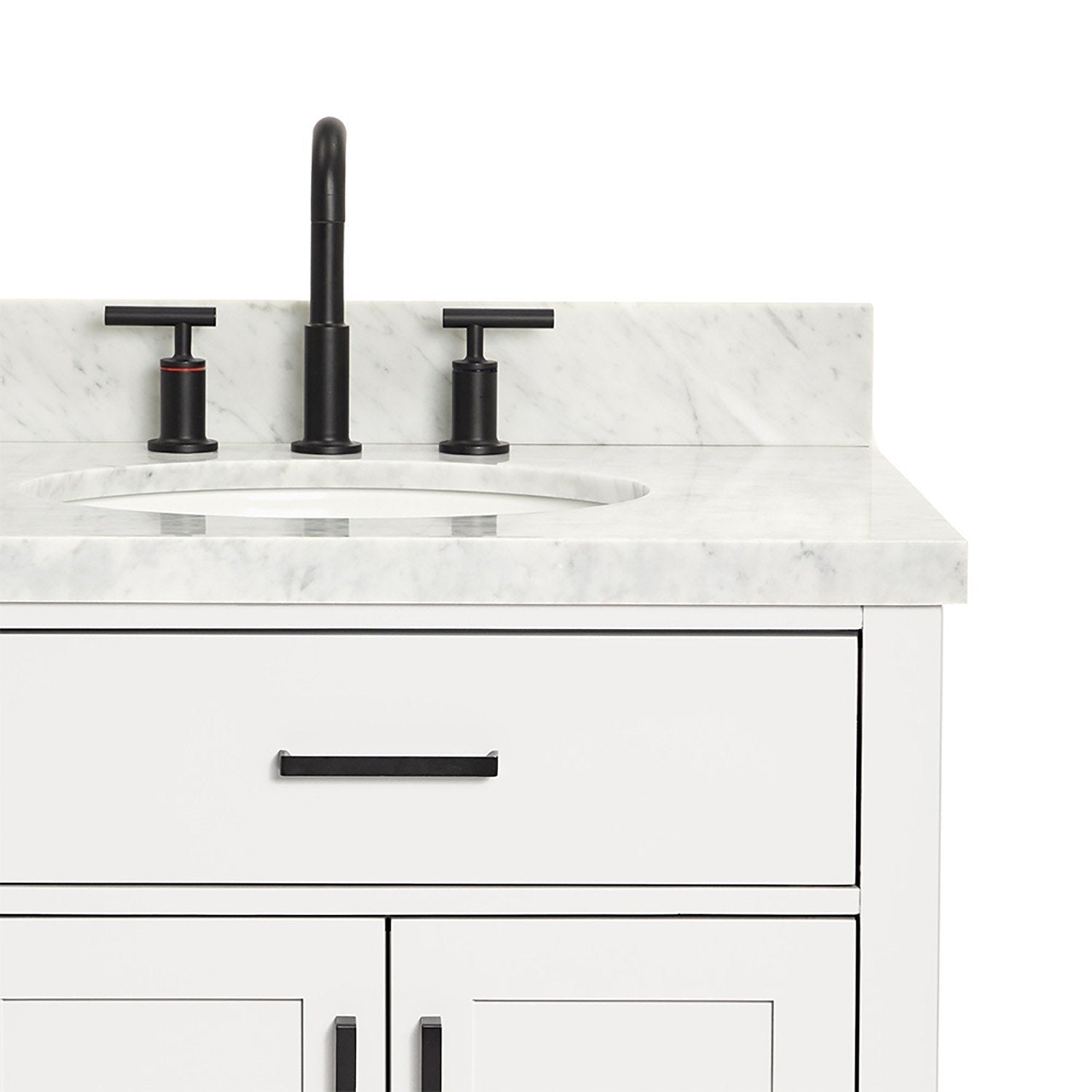 Close-up of a white wooden bathroom vanity with a stone marble top and backsplash, oval undermount sink, matte black three-piece faucet, and matching black drawer and door handles.