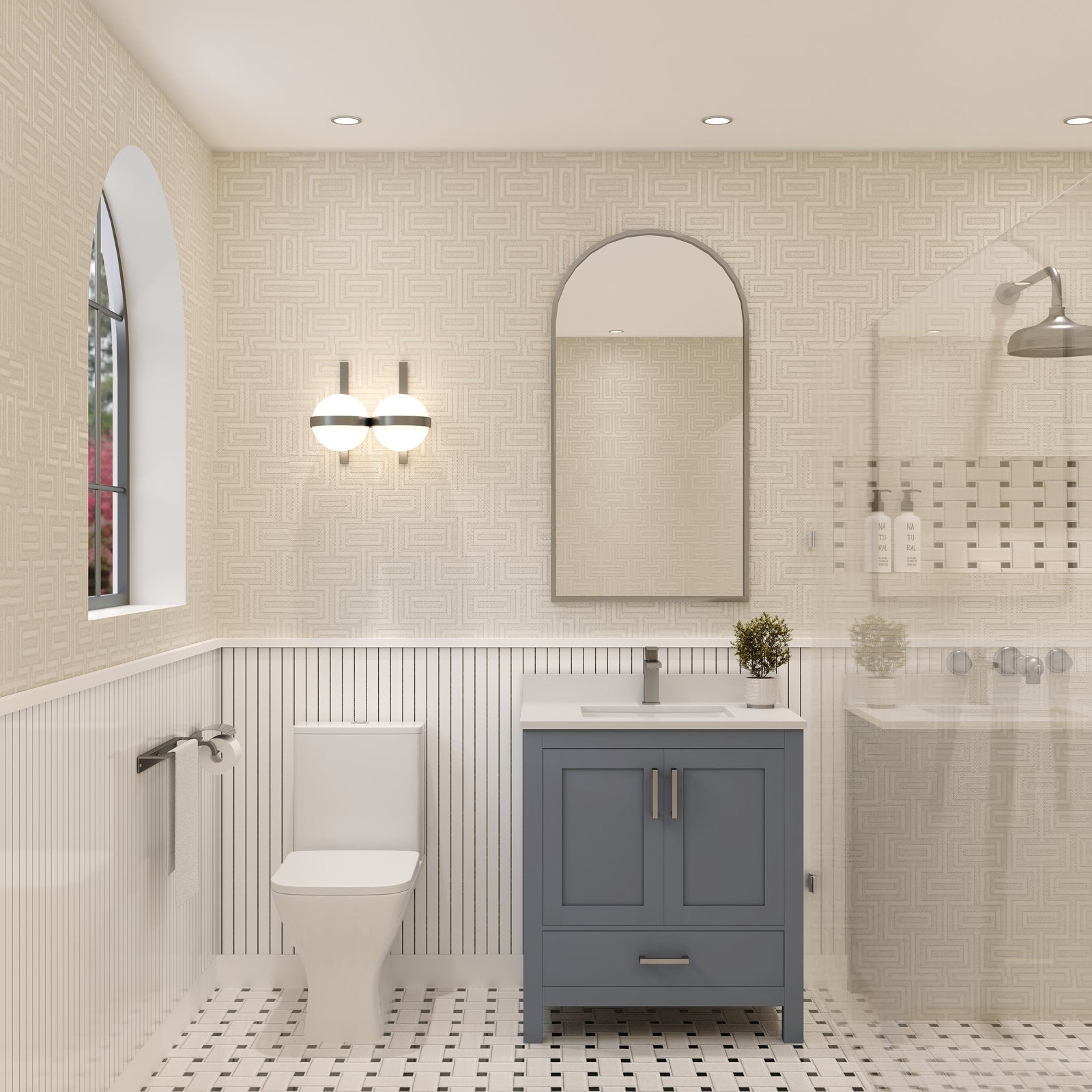 Modern solid wood bathroom vanity with stone countertop and integrated ceramic sink, gray-blue cabinet with chrome hardware, arched mirror and wall sconce above; toilet to the left and glass shower to the right.