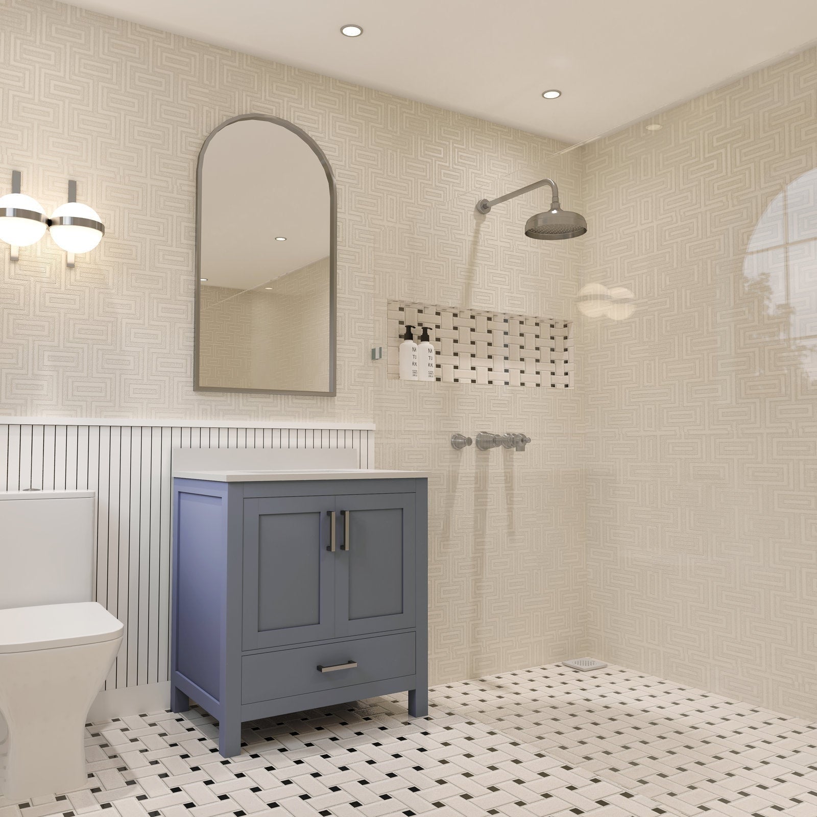 Freestanding 30-inch solid wood bathroom vanity in gray-blue with a white stone top, two doors and a bottom drawer with metal pulls, shown beside a walk-in shower with mosaic niche and patterned tile floor and walls.