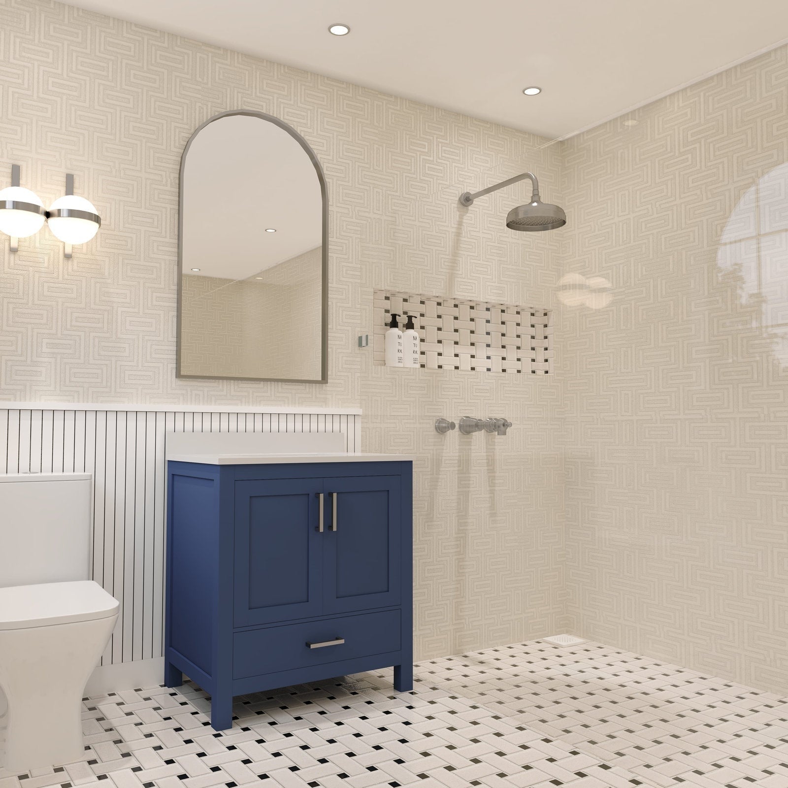 Freestanding navy solid-wood bathroom vanity with a white stone top and brushed metal pulls beneath an arched mirror, shown in a contemporary bathroom with beige patterned tile walls, black-and-white basketweave floor, wall sconce and showerhead.
