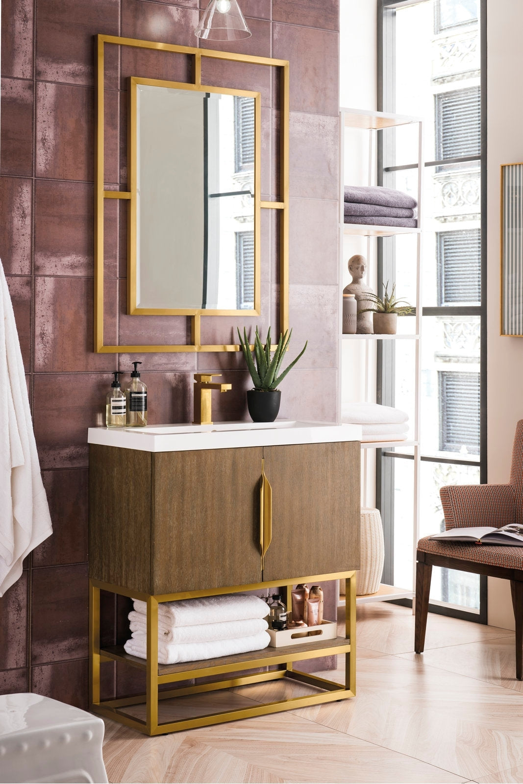 Contemporary single-sink bathroom vanity with a stone top, solid wood cabinet and gold metal base and hardware, pictured with a geometric gold-framed mirror, potted succulent on the counter and folded towels on the lower shelf.