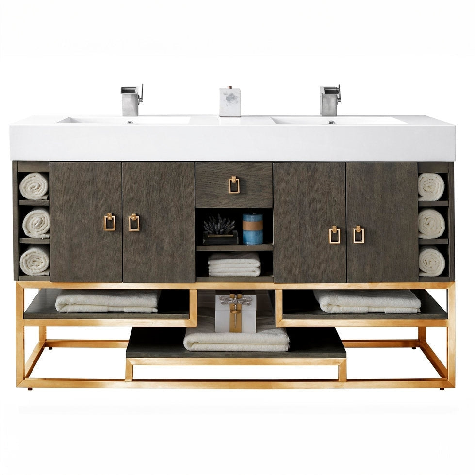 59-inch freestanding double-sink bathroom vanity with a white stone composite top and integrated rectangular sinks, stone-colored solid wood cabinet, gold metal base and square gold pulls, open shelves with rolled towels.