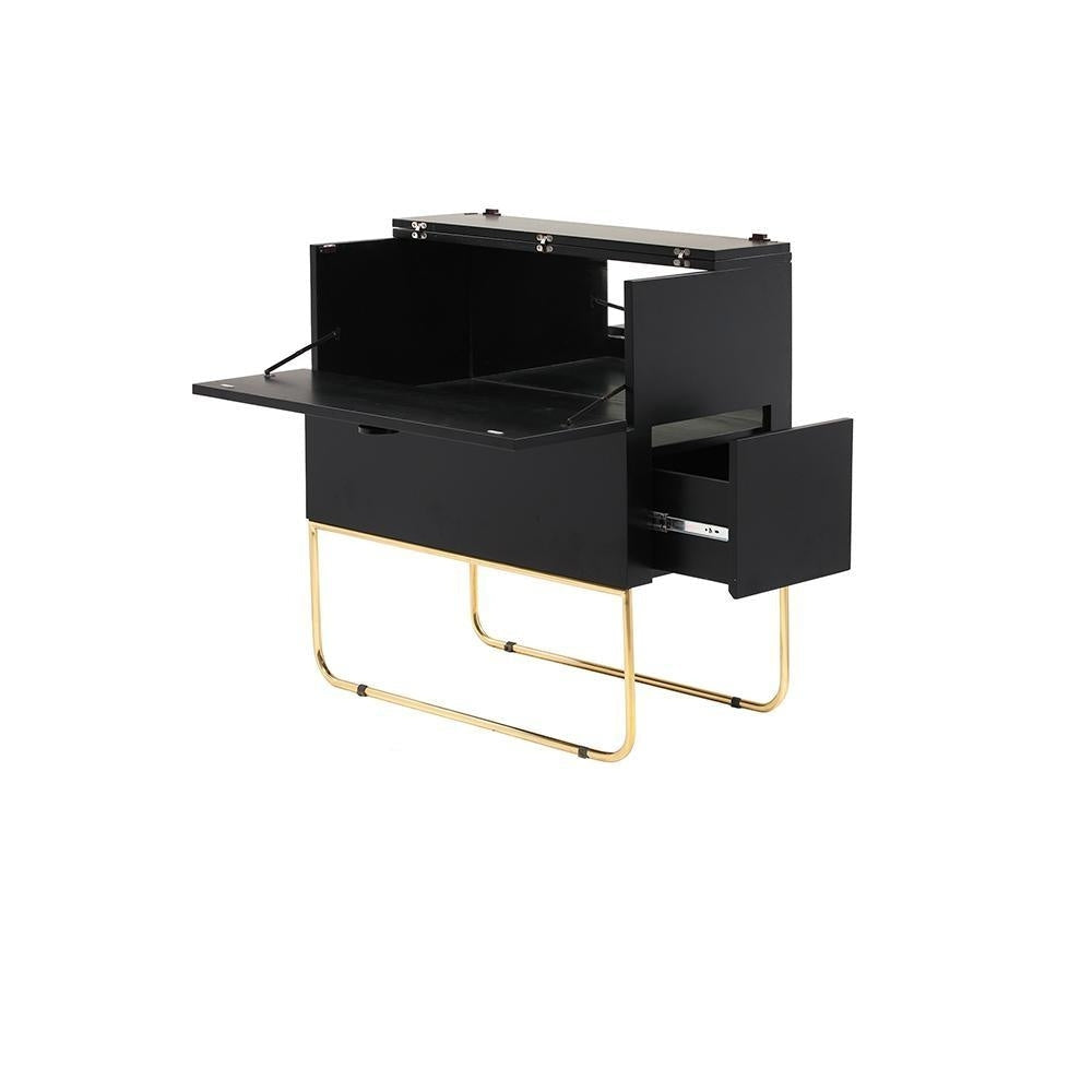 Black mahogany drinks cabinet with drop-front serving surface folded down and right-side drawer extended to reveal interior storage compartments; supported on polished brass tubular sled legs against a white background.
