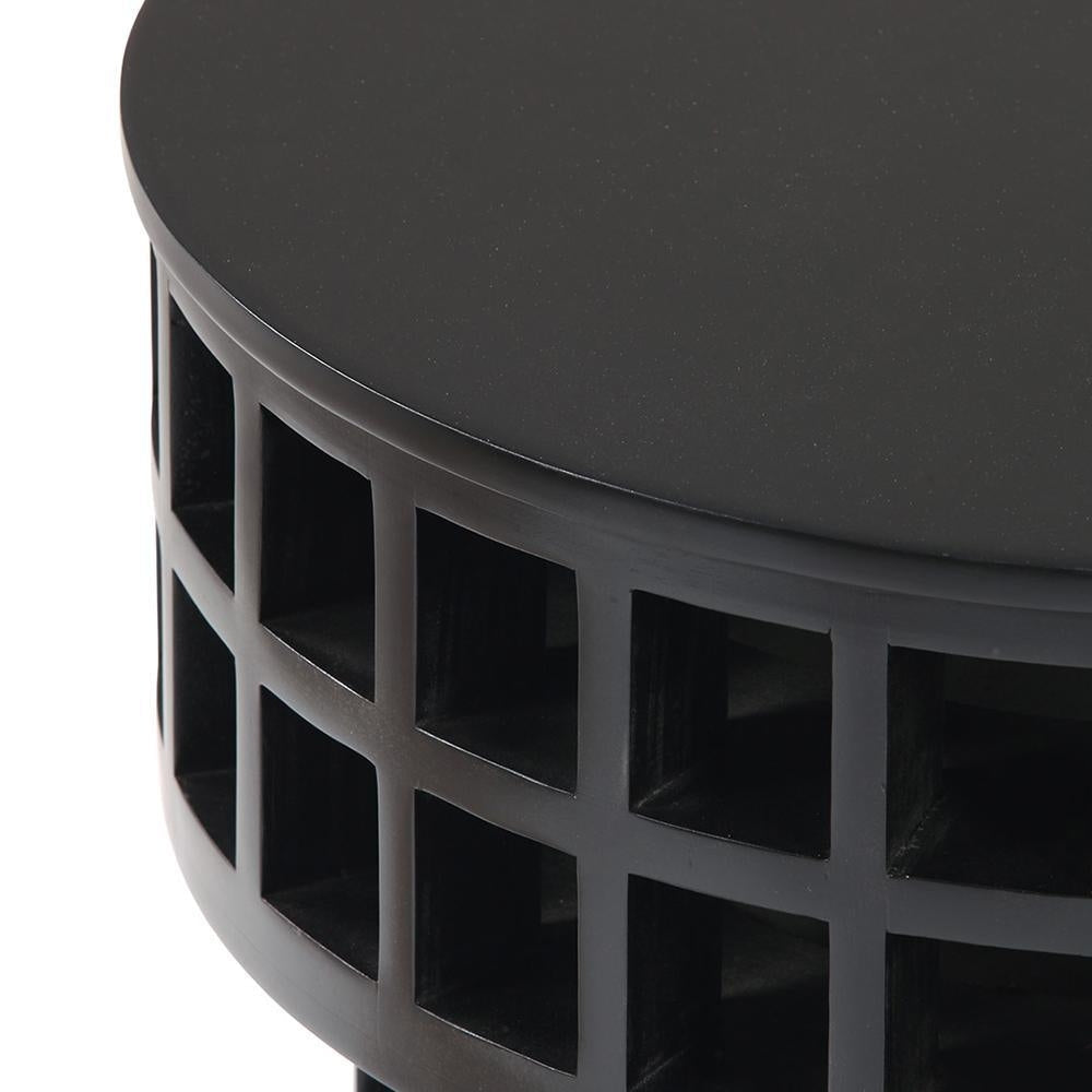 Close-up of a round mahogany-finish black wood side table showing the smooth top and open grid-lattice base with square cutouts, highlighting the modern solid wood construction.