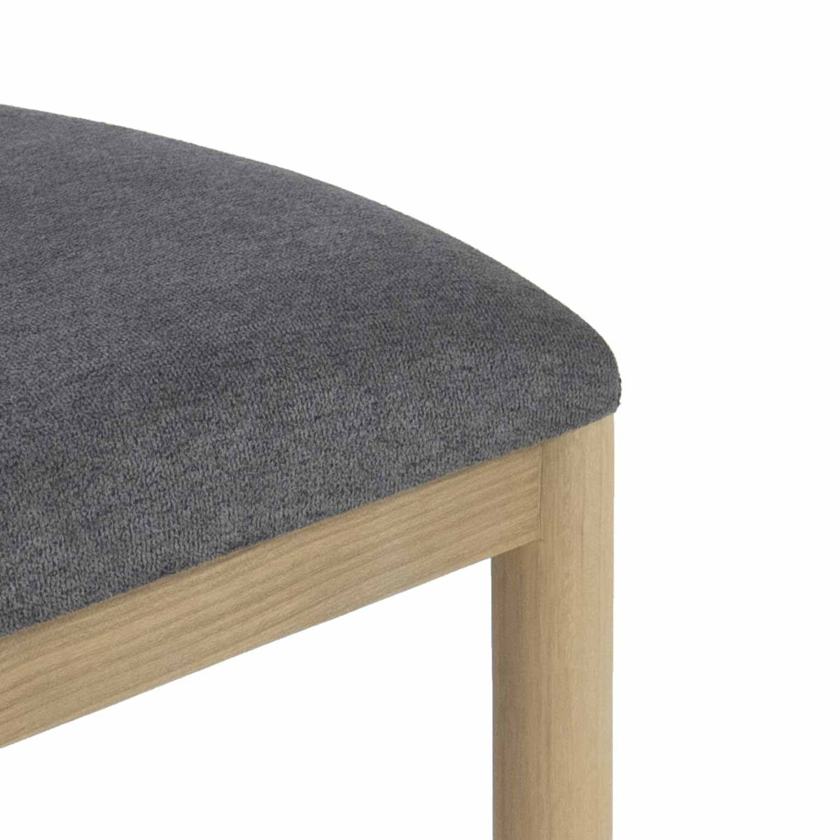 Close-up of a gray boucle upholstered seat cushion on a natural oak stool frame and rounded leg, highlighting the fabric texture and light wood grain.