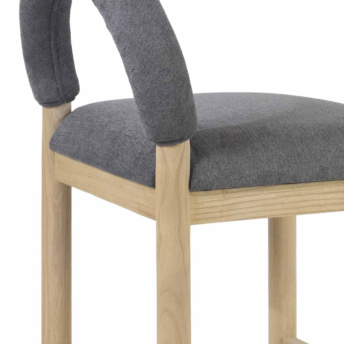 Close-up of a counter stool showing a cushioned gray boucle seat and low curved back wrapped in boucle fabric, supported by a natural oak frame and straight oak legs.