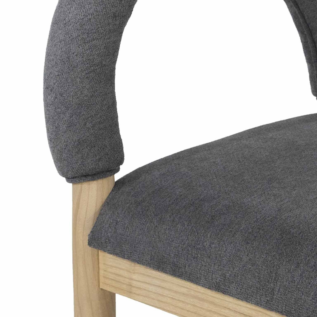Close-up of a stool showing a charcoal boucle upholstered seat and curved backrest with textured fabric and a natural oak leg and frame.