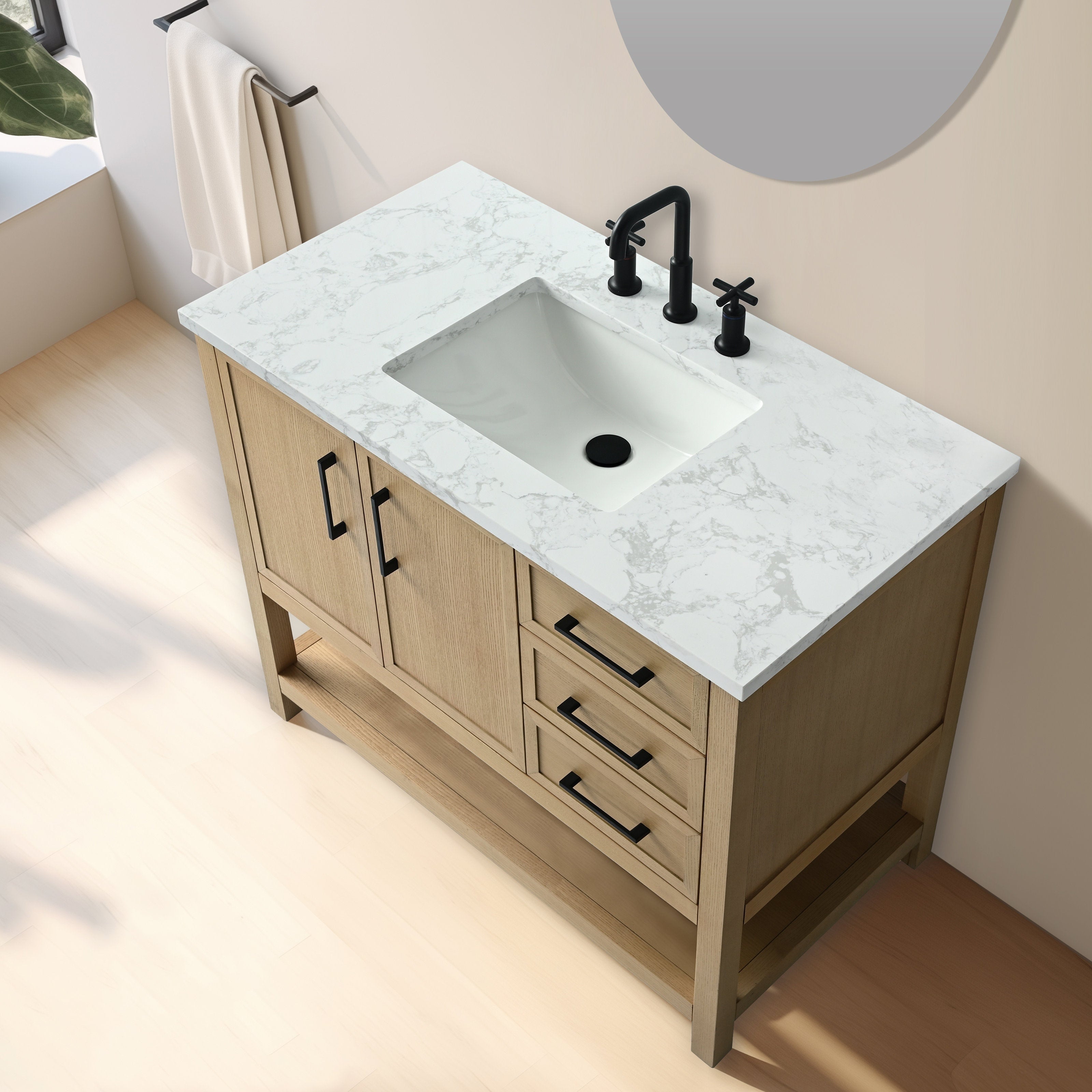 Angled top-down view of a 42-inch freestanding solid wood bathroom vanity in light brown with a white veined stone marble countertop, rectangular undermount ceramic sink, matte black faucet and hardware, three drawers and open lower shelf.