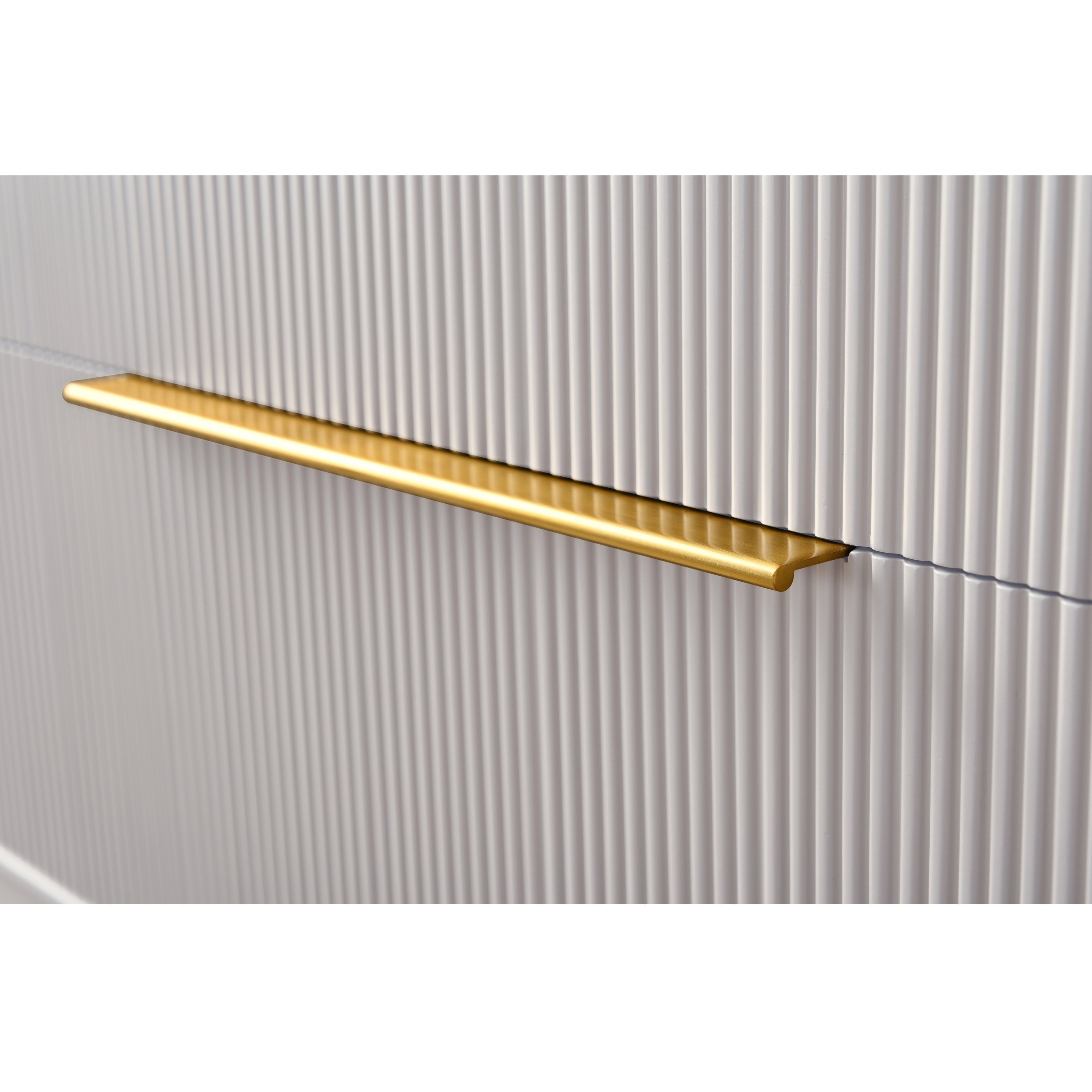 Close-up of a brushed brass bar handle mounted on a stone-colored, vertically ribbed wood vanity drawer front, highlighting the modern metal hardware and textured finish.
