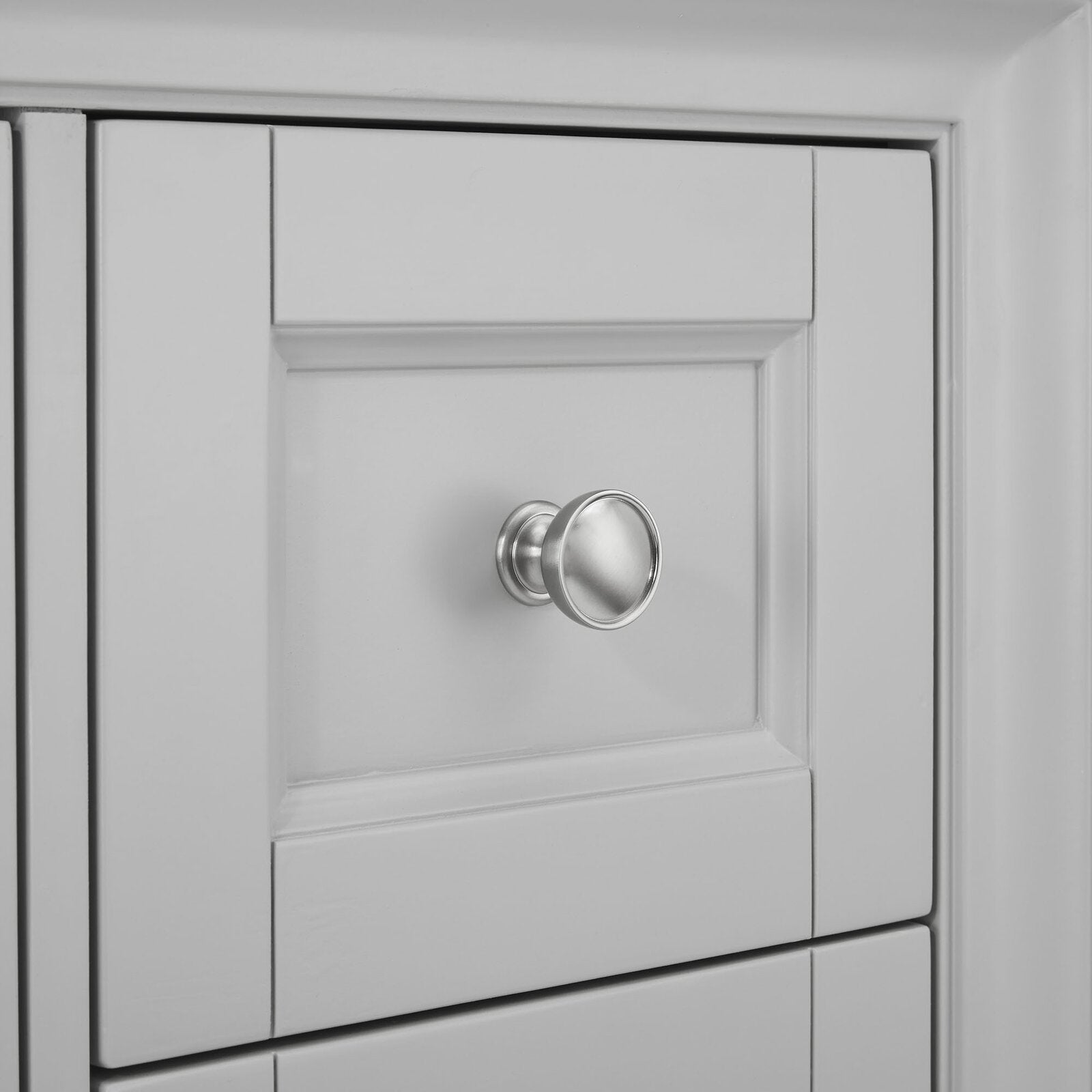 Close-up of a round satin nickel drawer knob mounted on a stone-gray solid wood vanity front with a recessed shaker-style panel and soft matte finish.