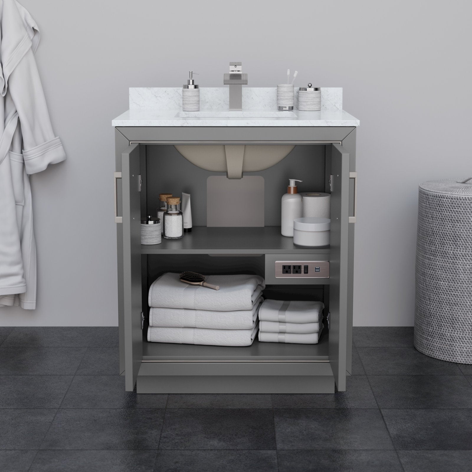 30-inch modern solid wood bathroom vanity in stone finish with a white stone countertop and integrated sink; open doors reveal two shelves with folded white towels, toiletries, a built-in outlet and square chrome faucet.