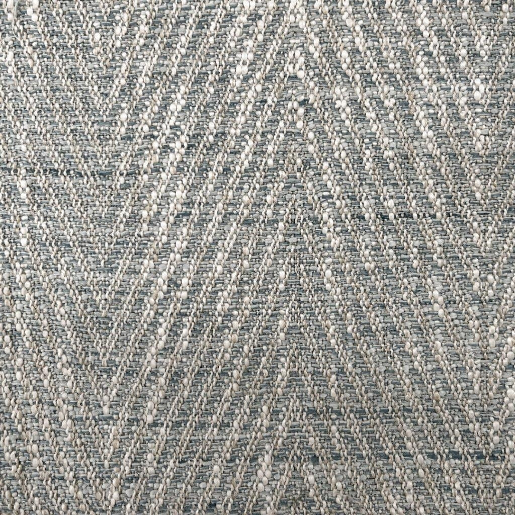 Close-up of lake herringbone upholstery fabric showing a textured chevron weave in blue-gray and cream yarns with raised boucle-like nubs.