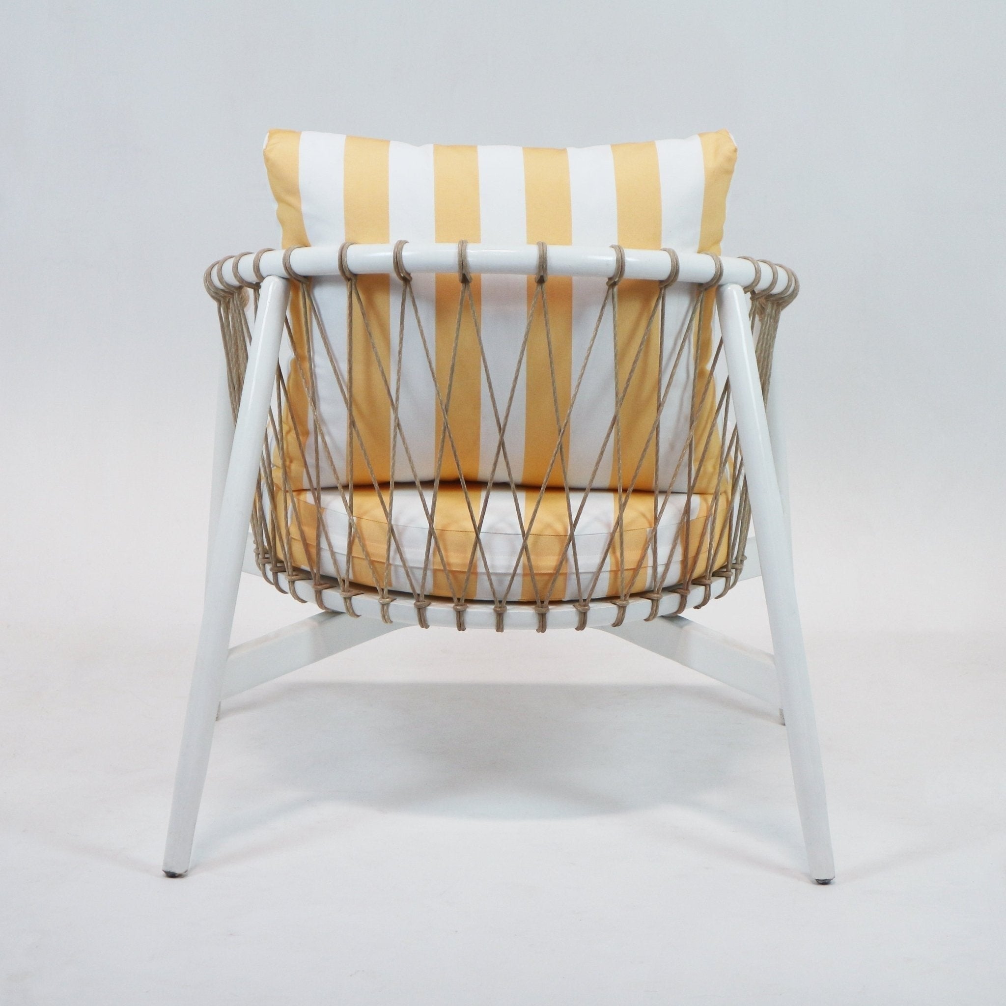 Rear view of a modern outdoor lounge chair with a white painted wood frame, woven natural rope sides, and yellow-and-white striped fabric back and seat cushions.