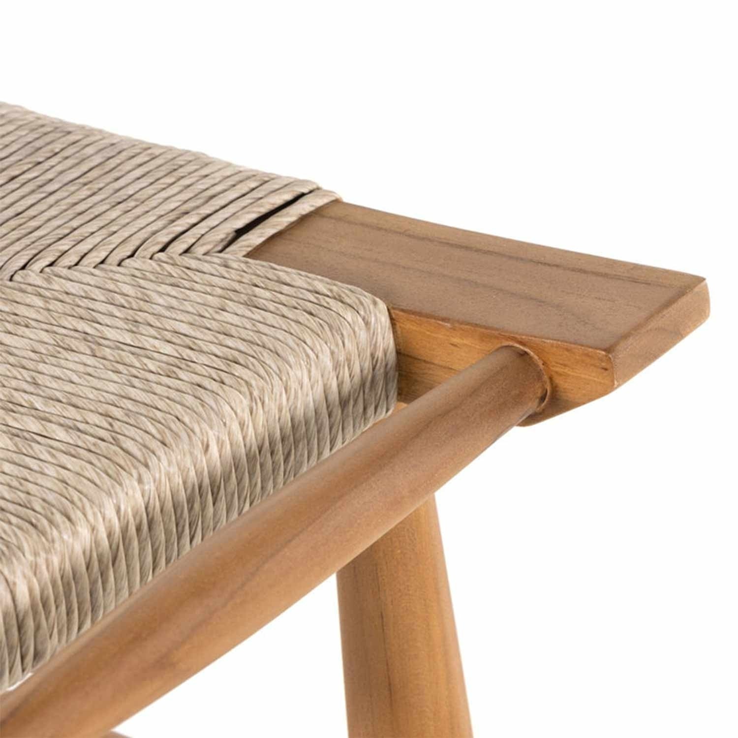 Close-up of a backless teak outdoor bar stool seat showing natural teak wood frame and tightly woven beige rope seat in a coastal Scandinavian style.
