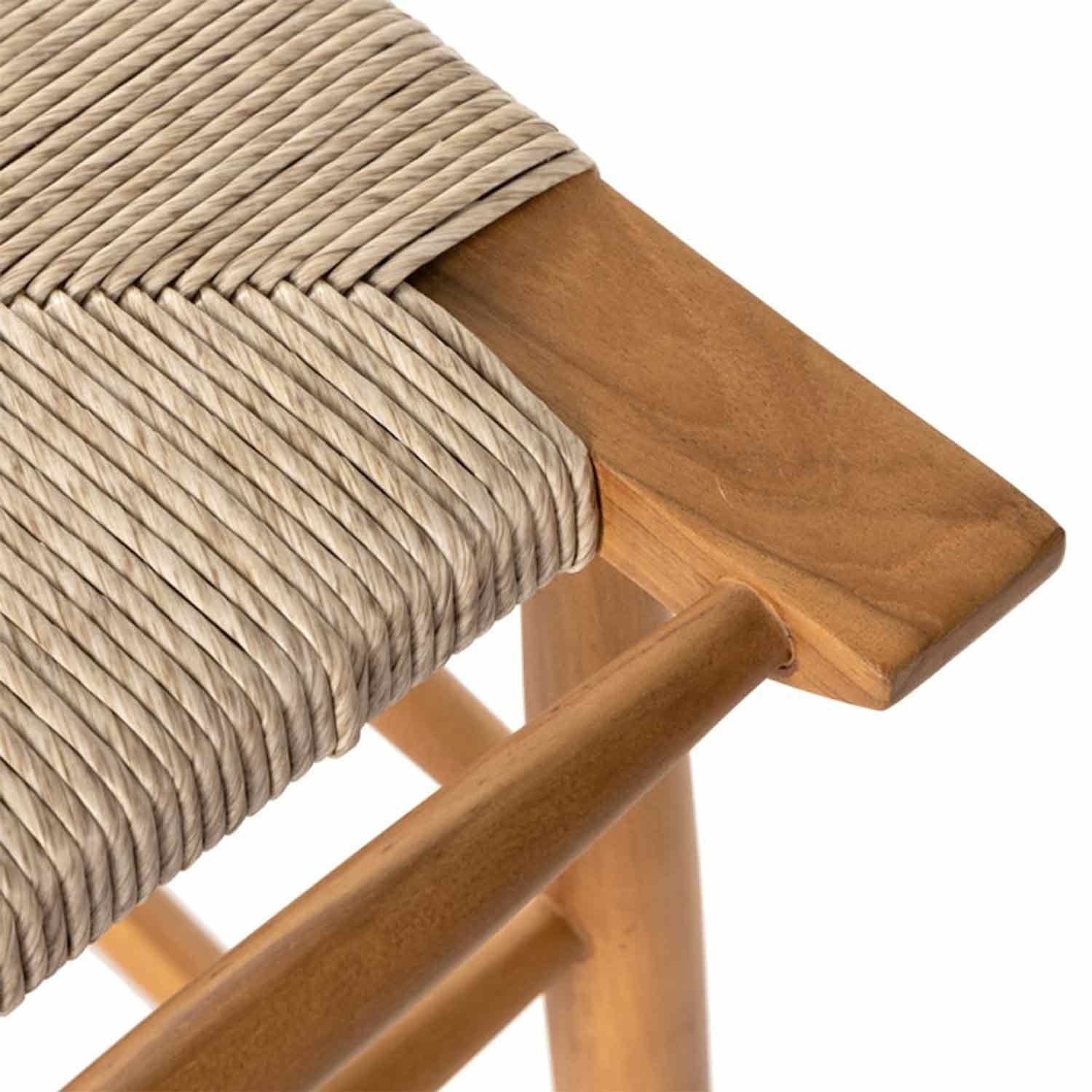 Close-up of a backless teak outdoor bar stool corner showing a natural teak wood frame and tightly woven beige rope seat, highlighting the woven detail and smooth wood grain.