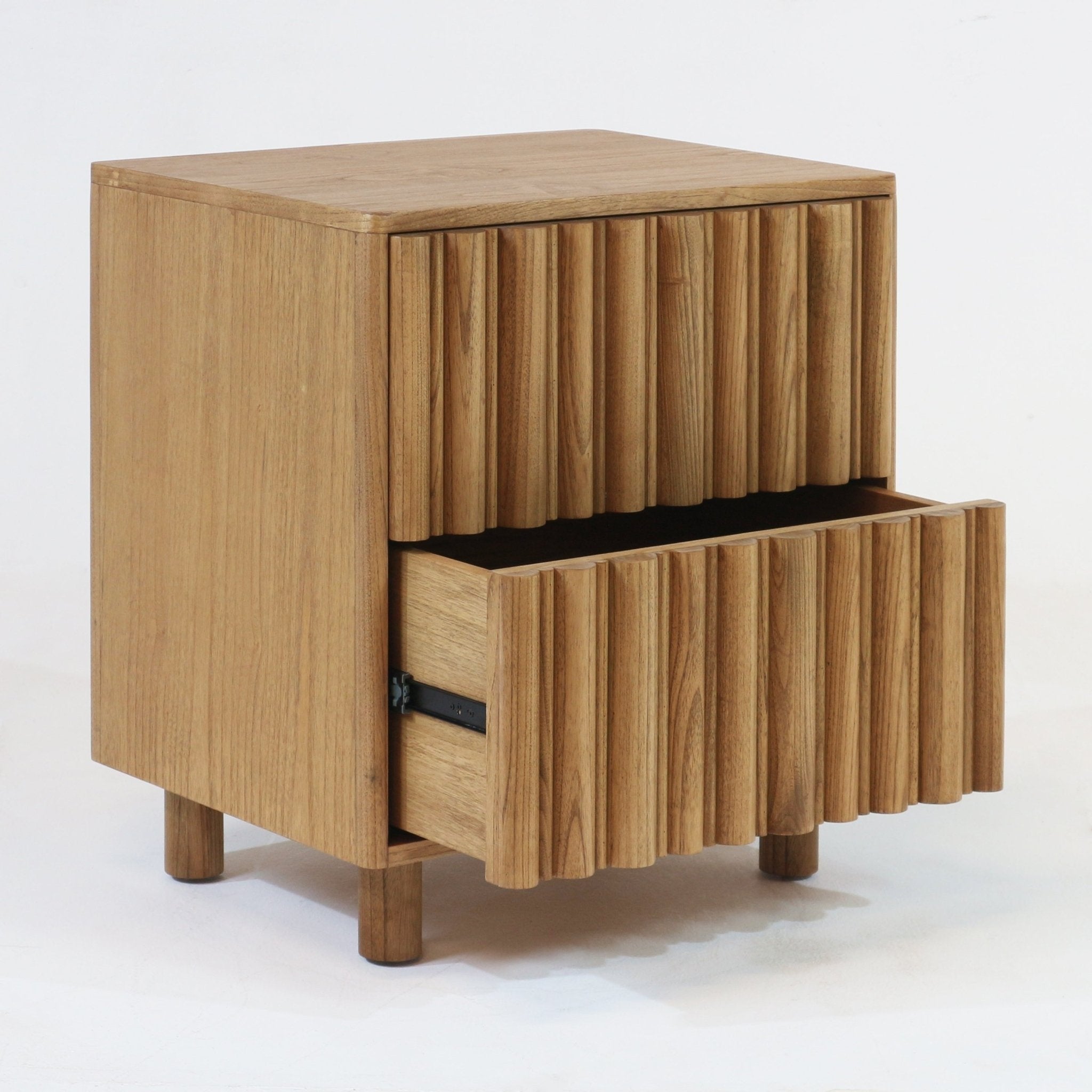 Light natural solid wood Scandinavian nightstand with fluted ribbed drawer fronts and round legs; lower drawer partially open revealing interior, minimalist modern bedside table in a blonde wood finish.