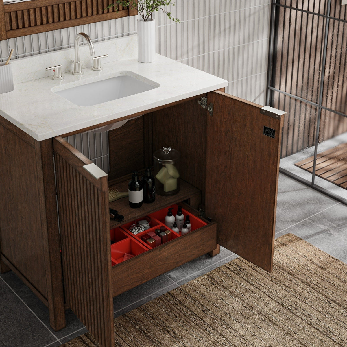 Freestanding modern fluted solid wood bathroom vanity with a stone-colored countertop, undermount ceramic sink, brushed nickel faucet and open doors showing interior shelf and red organizer with toiletries.