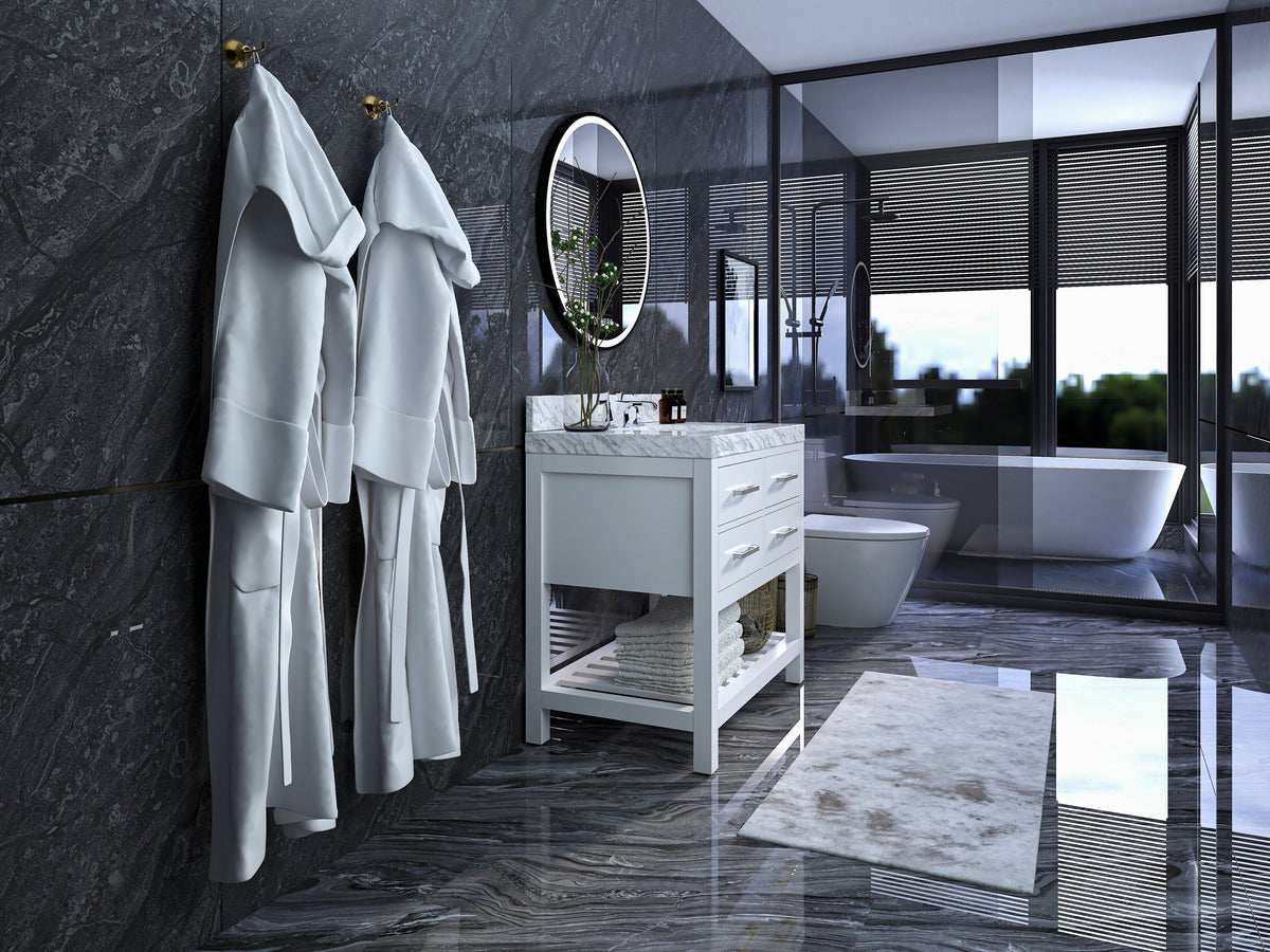 36-inch solid wood single-sink vanity in stone finish with a marble-look top, round mirror and open lower shelf, staged in a modern bathroom with dark marble walls, freestanding tub and hanging white robes.