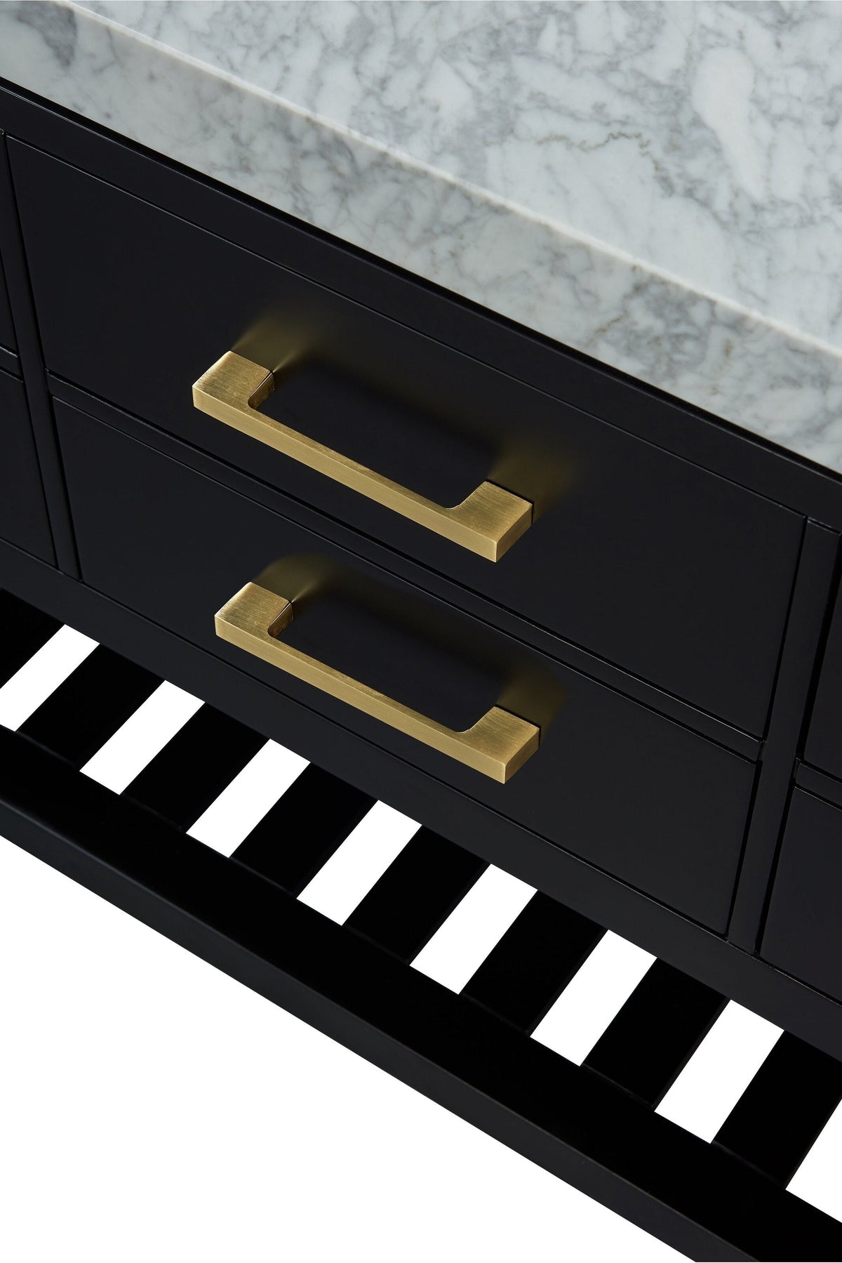 Close-up of a modern black solid wood bathroom vanity with a stone marble top, two brushed-gold rectangular drawer handles, and a black slatted lower shelf.
