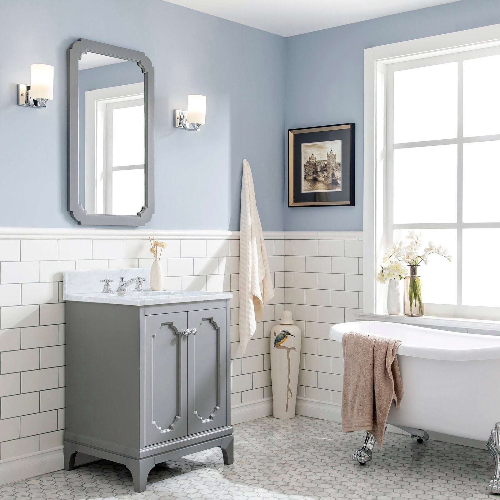 Cashmere grey 30-inch single-sink vanity with Carrara white marble countertop, chrome classic faucet and matching mirror, styled in a light-blue bathroom with white subway tile, wall sconces, decorative vase and clawfoot tub.