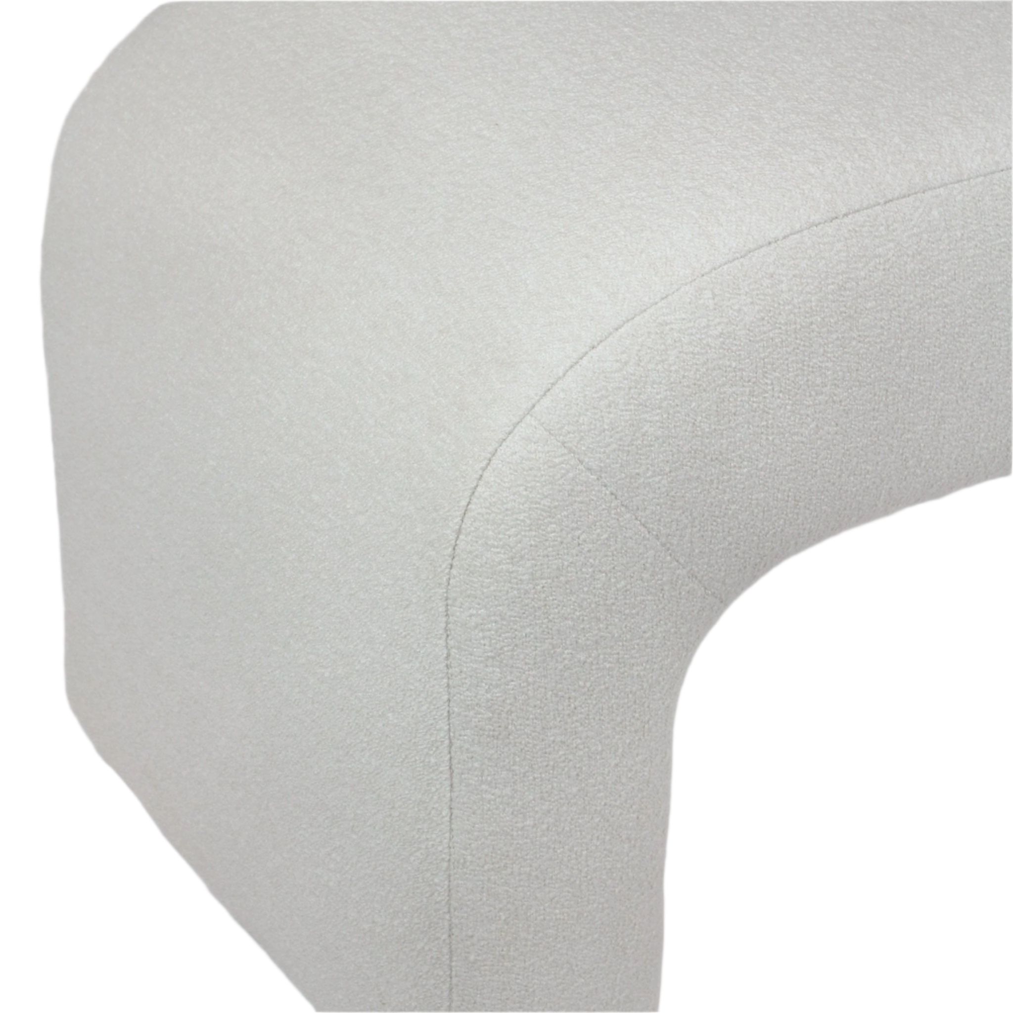 Close-up of a cream boucle upholstered bench corner showing the rounded curved profile, visible seam and textured looped fabric on a modern end-of-bed bench.