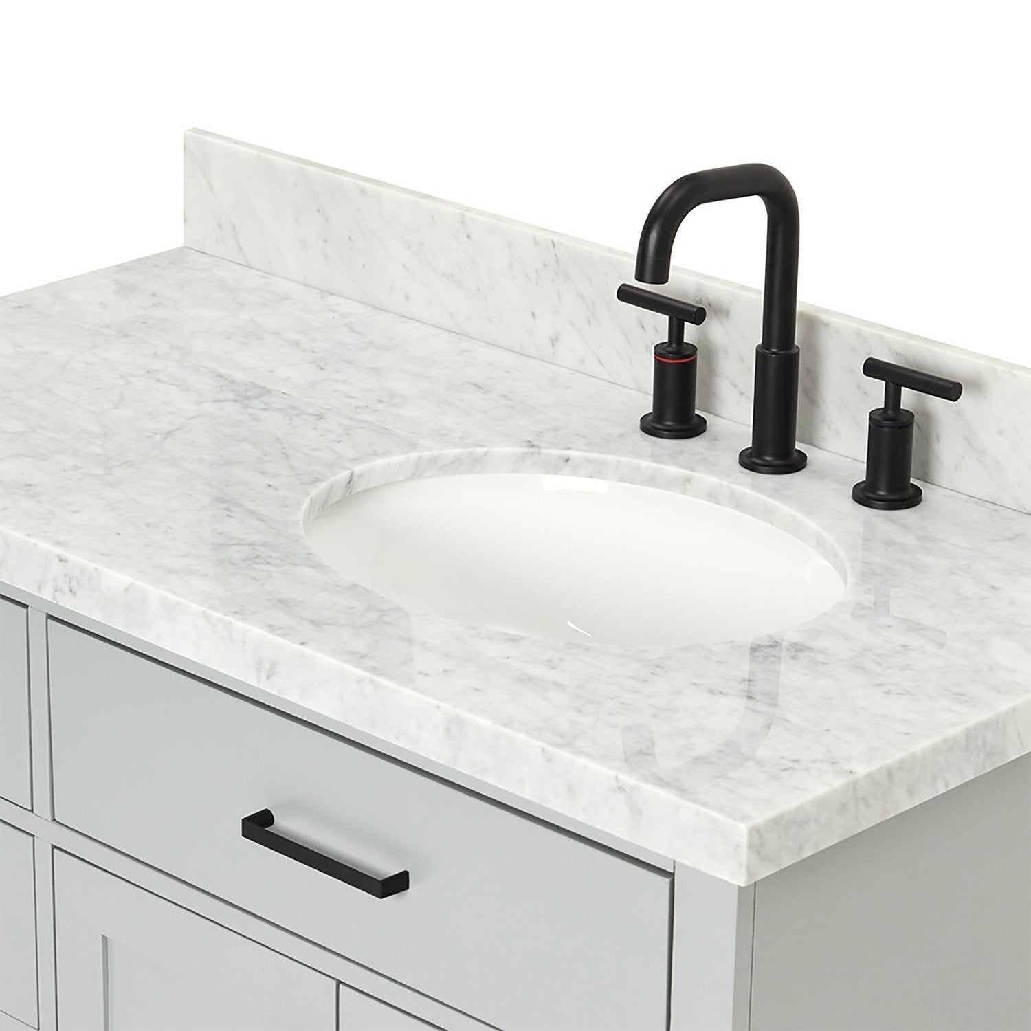 Close-up of a stone marble countertop with an oval white undermount ceramic sink, matte black three-piece faucet and matching handles, sitting above a light stone-colored solid wood vanity drawer with black bar pull.