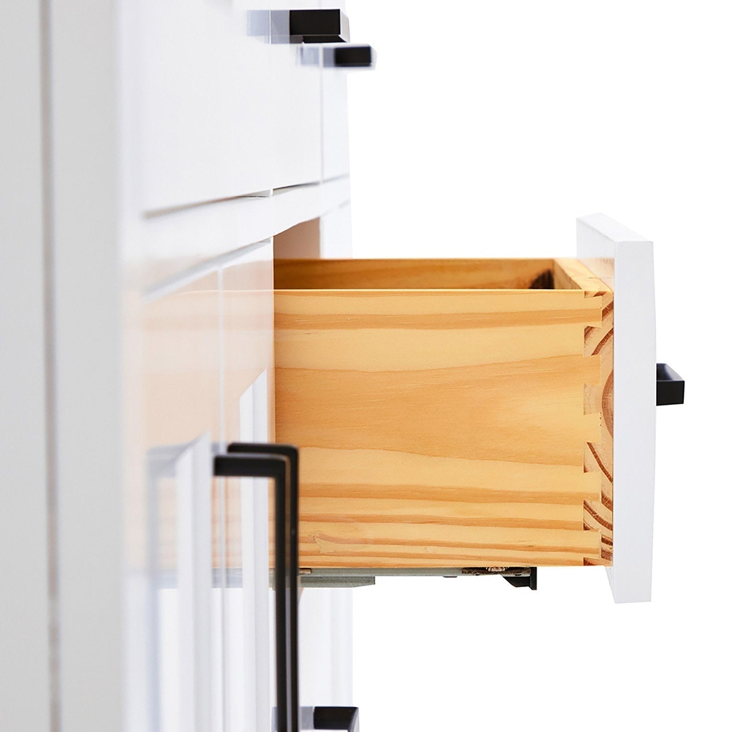 Close-up of a white modern bathroom vanity drawer pulled open to reveal a natural solid wood interior with dovetail joints, a matte black rectangular handle and metal drawer slide beneath the painted front.