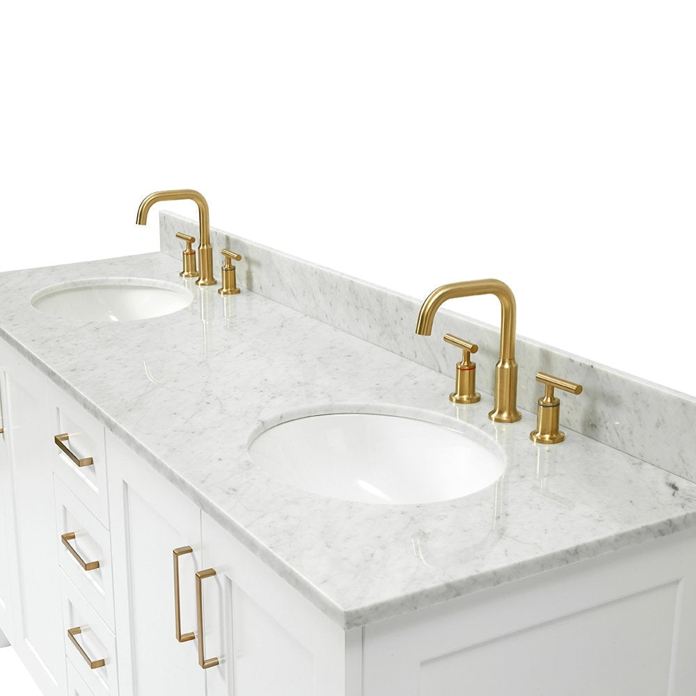 White solid-wood bathroom vanity with a gray-veined marble stone top, two undermount white sinks, and satin bronze faucets with matching bronze drawer and cabinet handles.