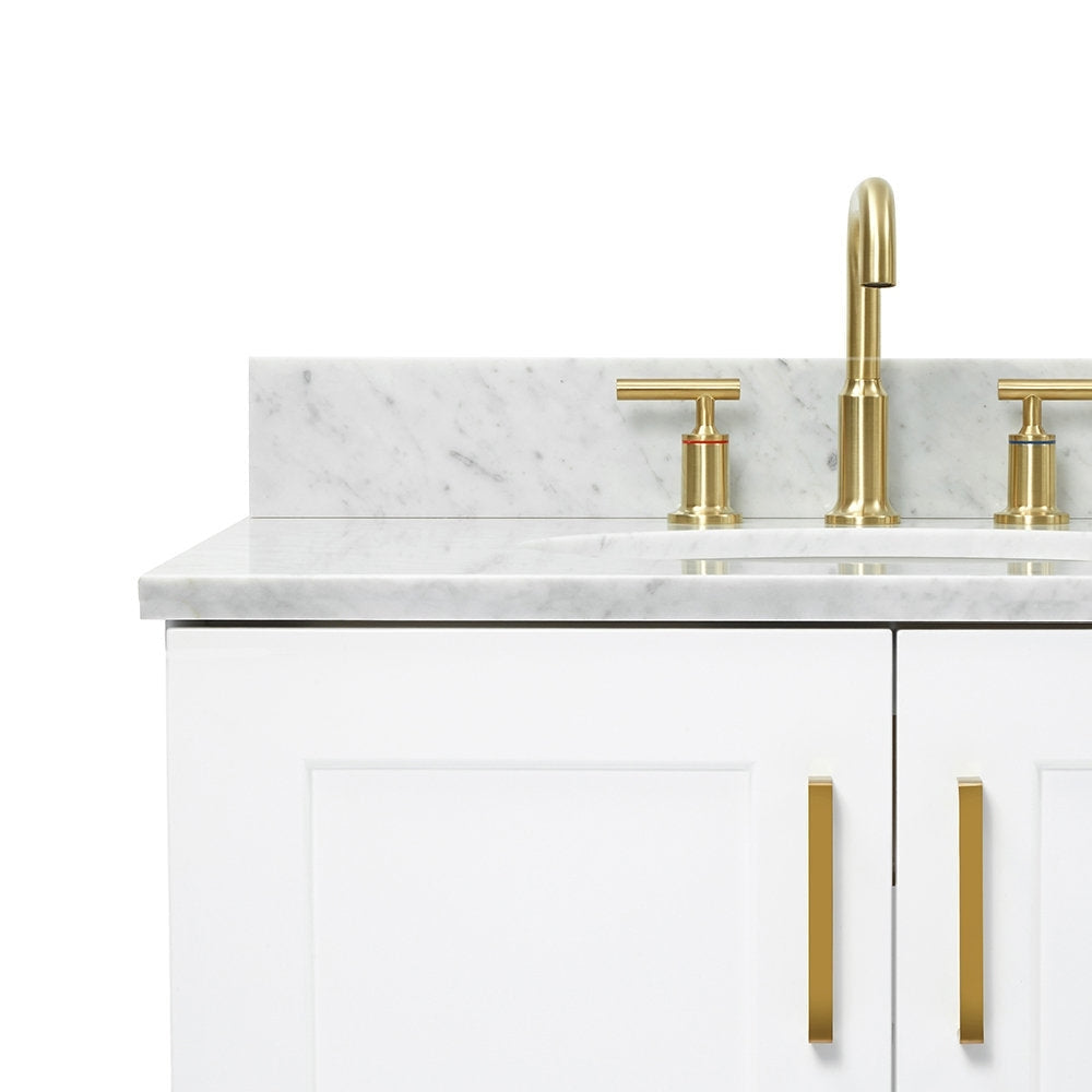 Close-up of a white solid-wood bathroom vanity with a stone marble top and backsplash, oval basin, satin-bronze faucet and matching bronze vertical cabinet pulls.