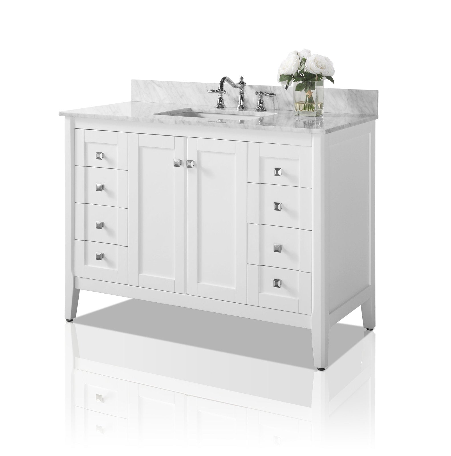 Freestanding white solid wood bathroom vanity with stone marble top and backsplash, single rectangular undermount sink with chrome faucet, three stacked drawers on each side, central double doors, square chrome knobs and a vase of white roses.