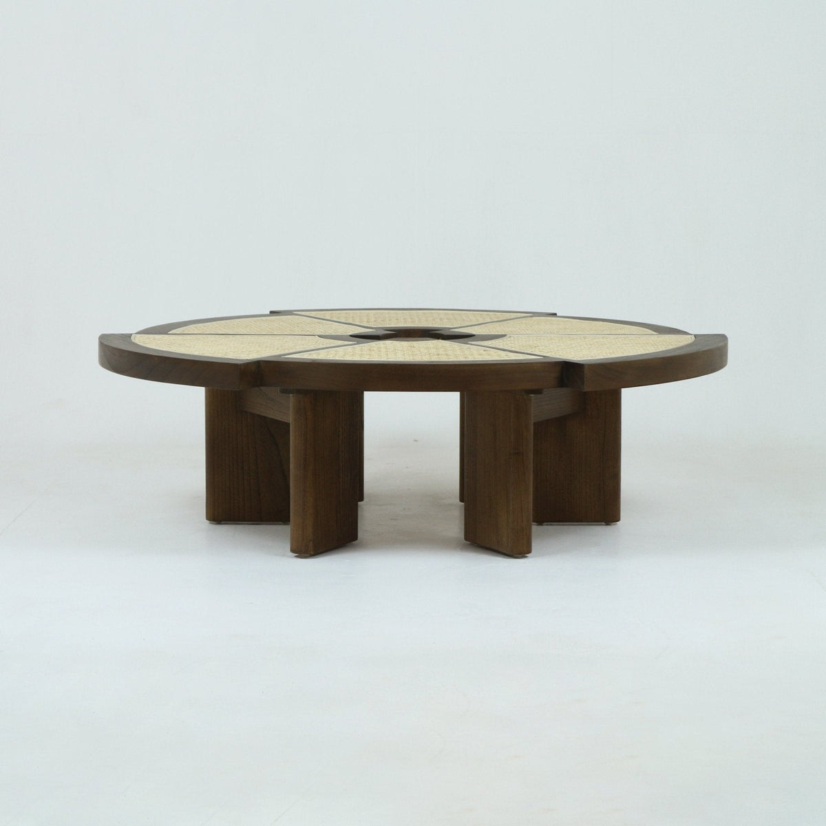 Low round coffee table in natural oak with woven cane inset top divided into radial segments, supported by thick solid-wood pedestal legs, showcasing a minimalist mid-century modern silhouette.