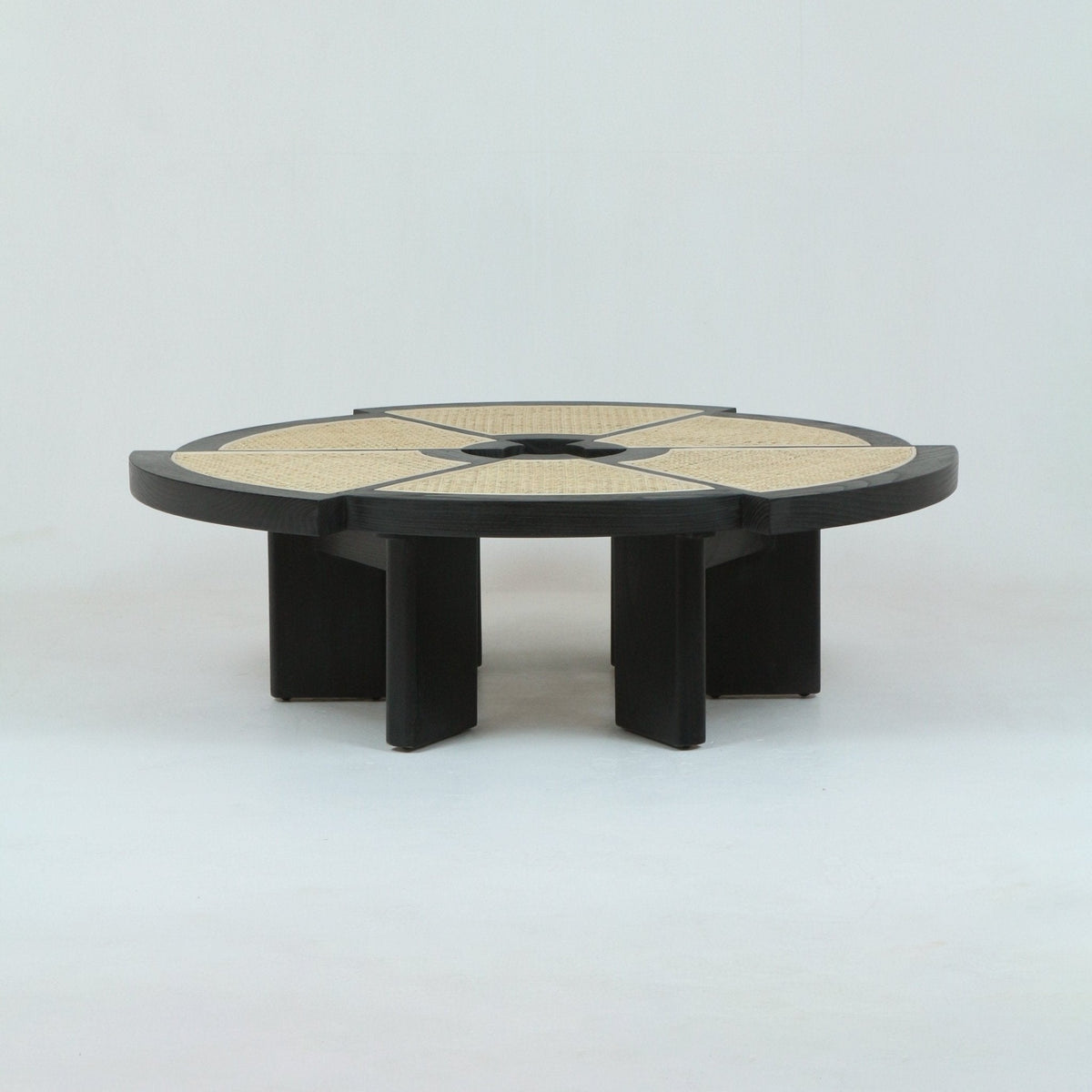 Low round coffee table with segmented woven cane inlays set into a natural oak rim and crossed center, supported by sculptural oak legs for a minimalist mid-century modern look.