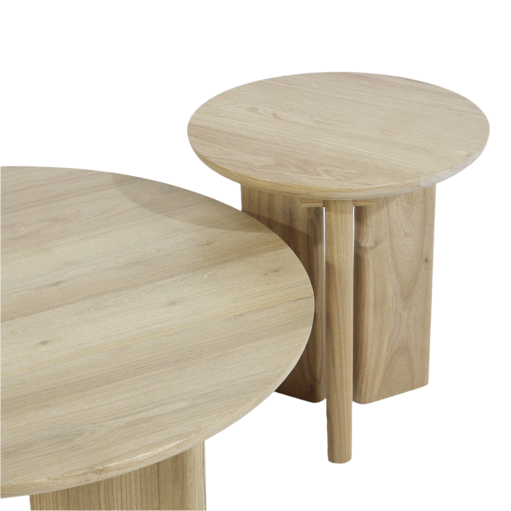 Two round solid oak coffee tables in a light natural oak finish, showing visible wood grain and smooth edges; a larger low table overlaps a smaller, taller table with cylindrical pedestal legs on a white background.