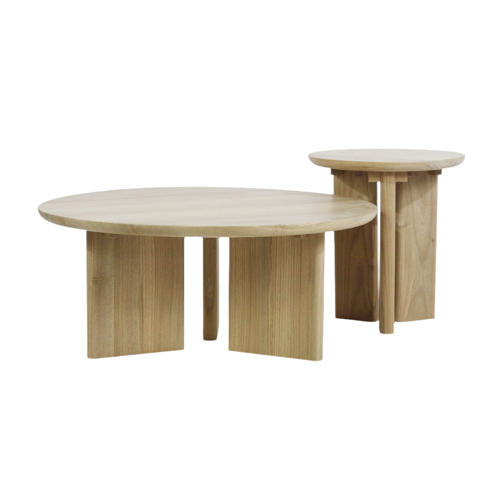 Pair of round solid oak nesting tables in a natural oak finish; a low coffee table with a thick round top and panel-style legs paired with a taller matching side table with the same round top and leg design.
