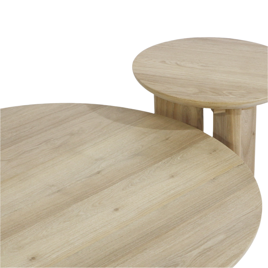 Close-up of two round solid oak nesting coffee tables in a light natural oak finish, showing the smooth wood grain tops and chunky rectangular legs in a modern style.