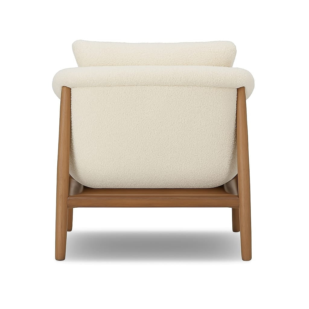 Rear view of a modern mid-century accent chair upholstered in cream boucle fabric with a natural wood frame and tapered legs, showing the rounded back cushion and wooden base.