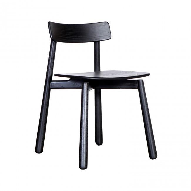 Black-stained mahogany Danish dining chair with a curved low backrest, contoured wooden seat and tapered round legs in a minimalist mid-century modern design.