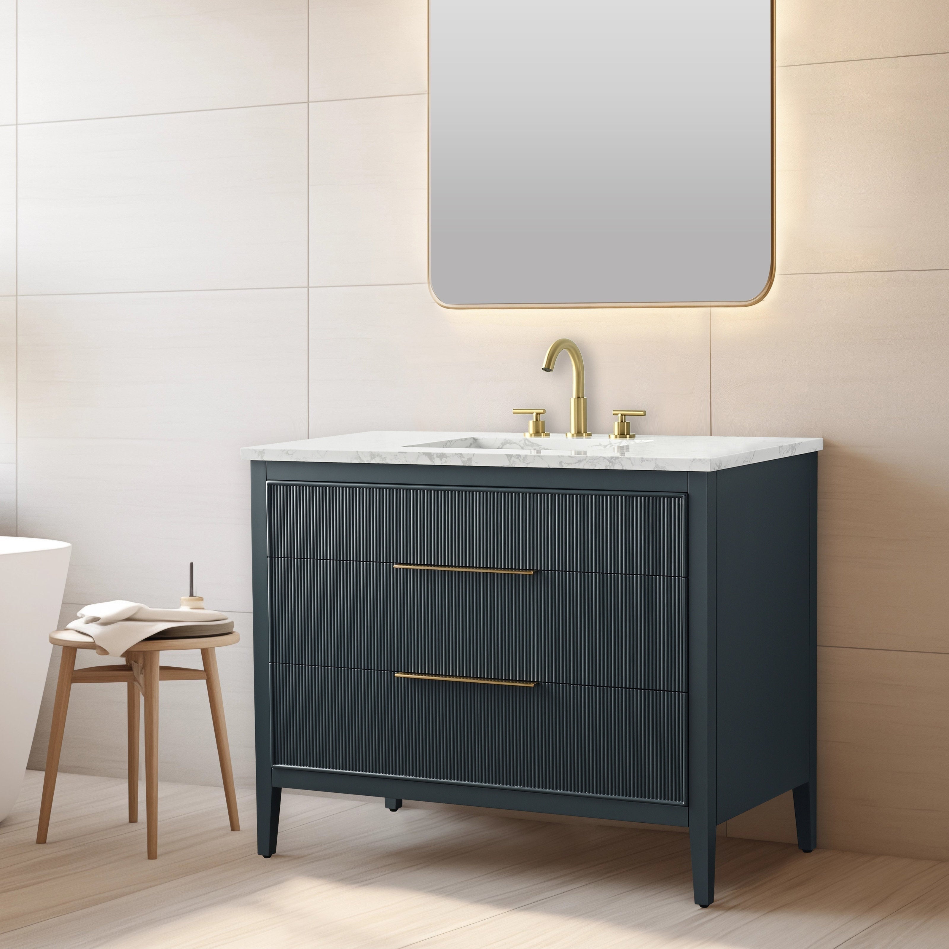 Modern single-sink solid wood vanity with ribbed drawer fronts, stone countertop and brass faucet and pulls, freestanding on tapered legs beneath a backlit mirror in a neutral bathroom setting.