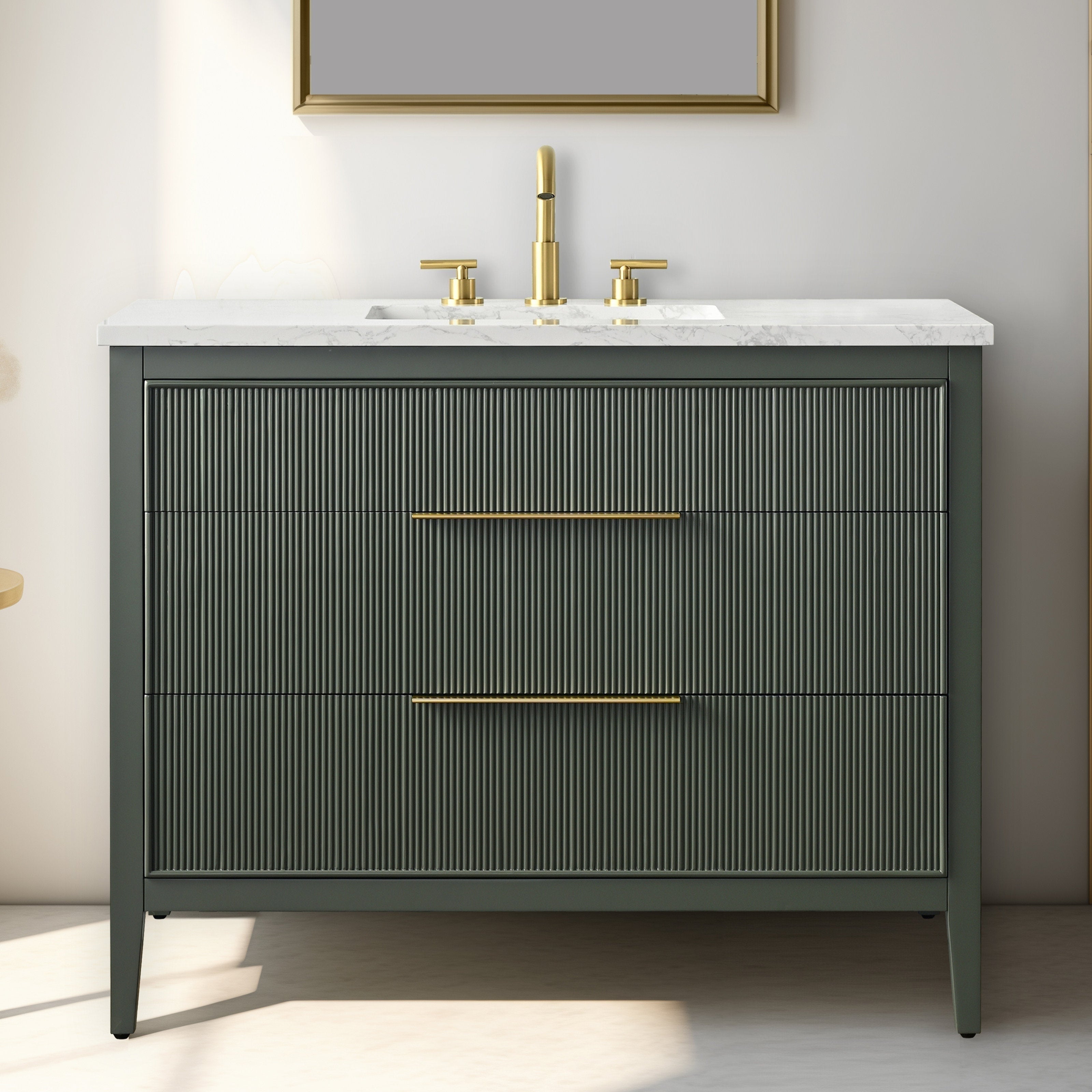 Freestanding modern solid wood bathroom vanity with white stone countertop and integrated rectangular sink, dark stone-colored ribbed drawer fronts, slim brass handles and matching brass faucet.