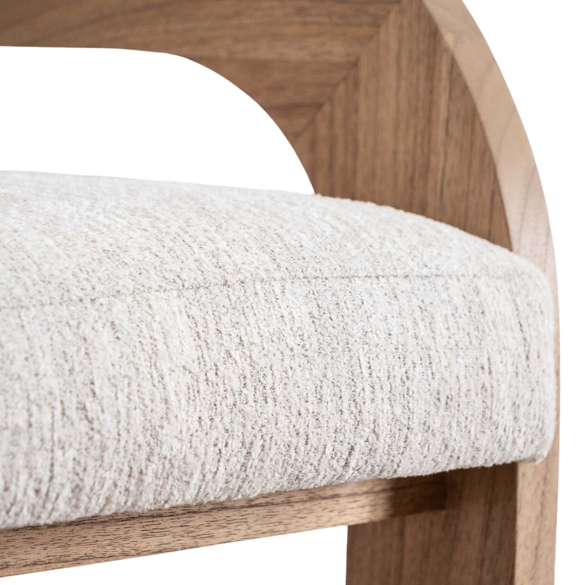 Close-up of a cream fabric-upholstered counter stool seat with textured fabric and a curved natural wood U-shaped back showing stitching detail and wood grain.