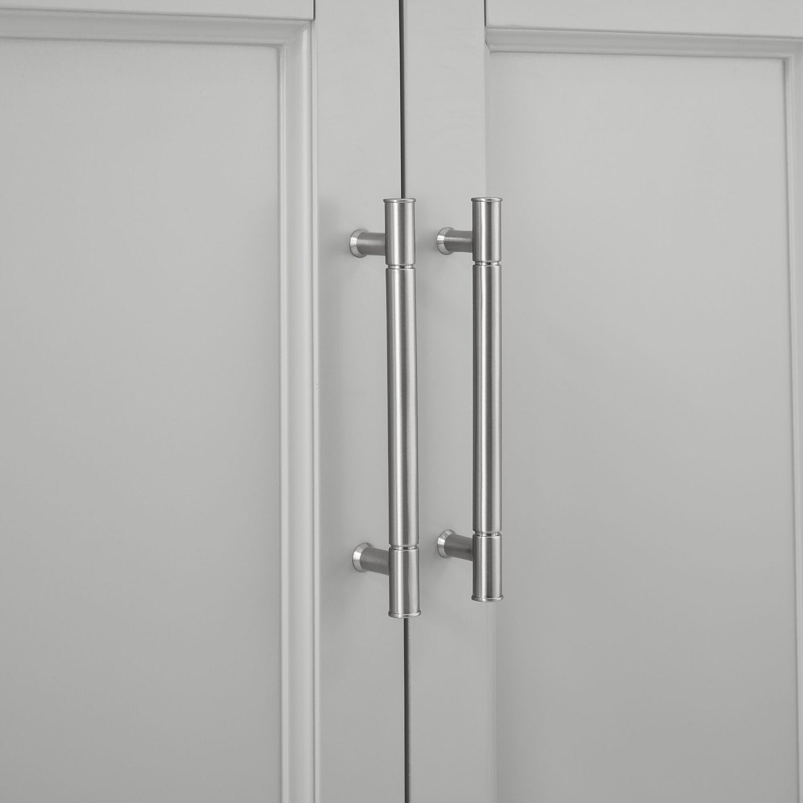 Close-up of two brushed-nickel vertical bar handles mounted on the stone-colored modern bathroom vanity's recessed solid wood doors.