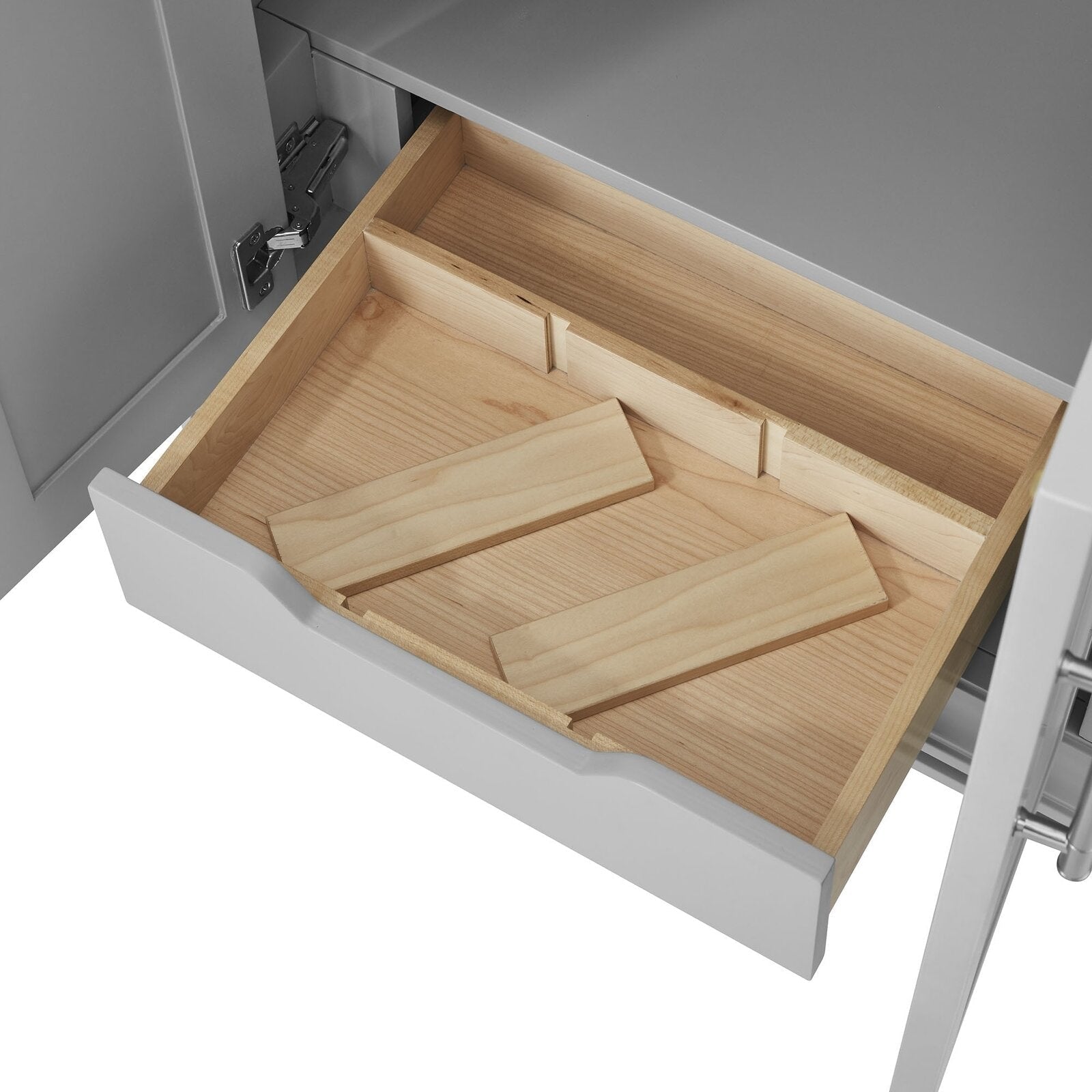 Open stone-colored bathroom vanity drawer revealing a solid wood interior with two removable wooden slats, visible hinge hardware and a scalloped drawer front showing natural wood grain and construction details.