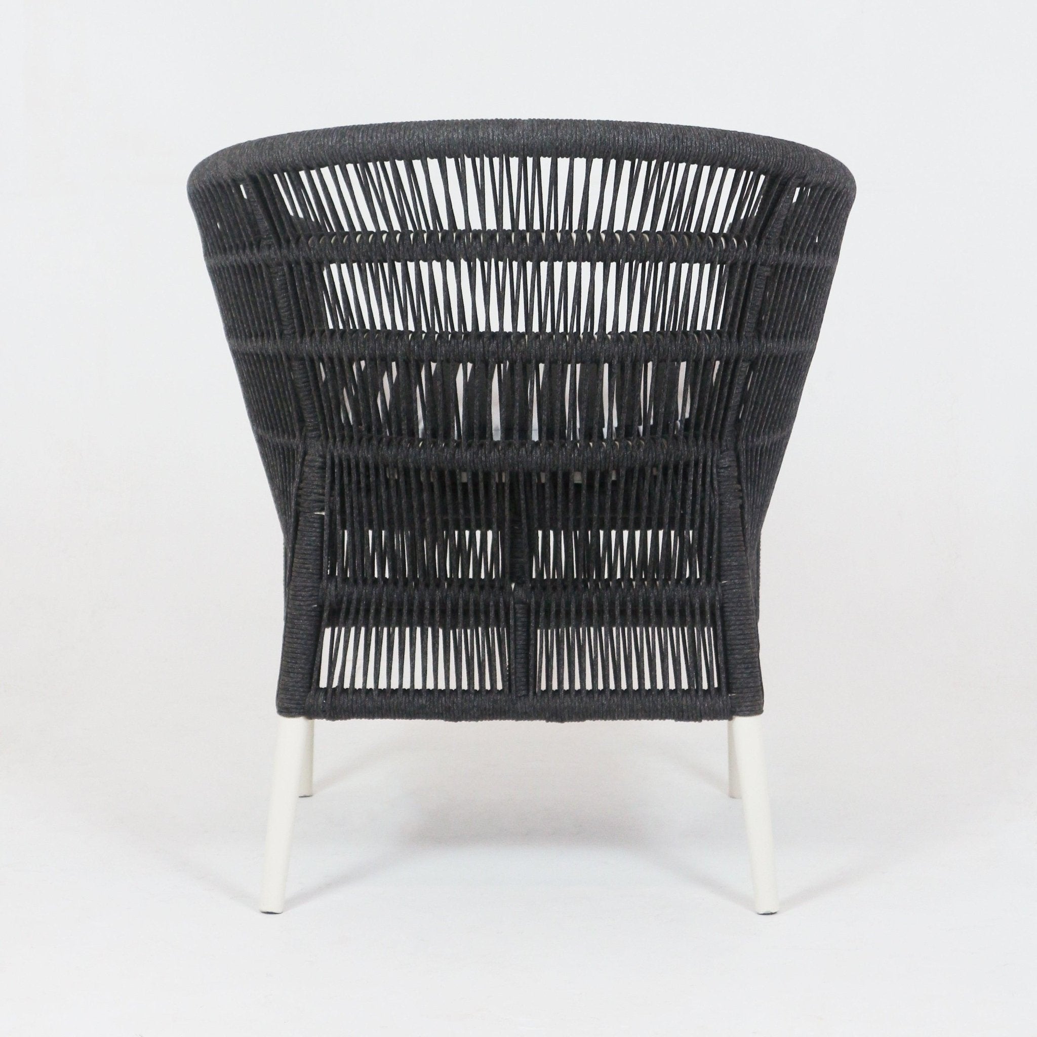 Back view of a dark rope-woven outdoor chair showing a flared open-weave backrest and tapered white metal legs against a plain white background.