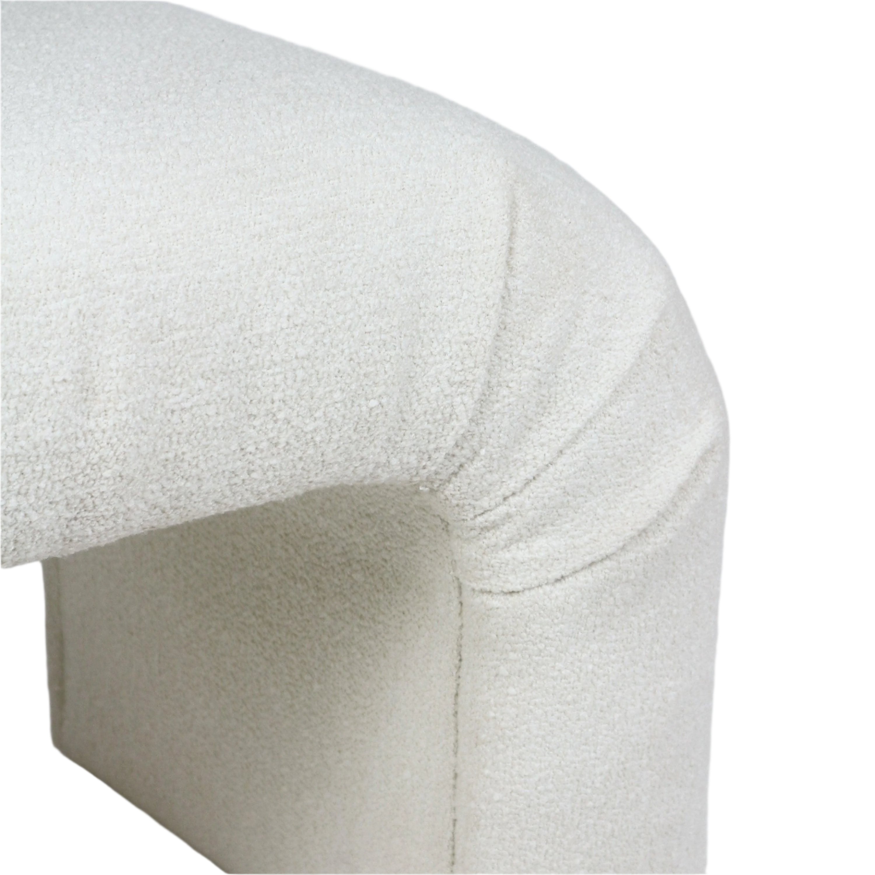 Close-up of a cream boucle-upholstered vanity seat corner showing soft looped texture, rounded cushion edge and a subtle seam where the upholstery wraps around the bench frame.