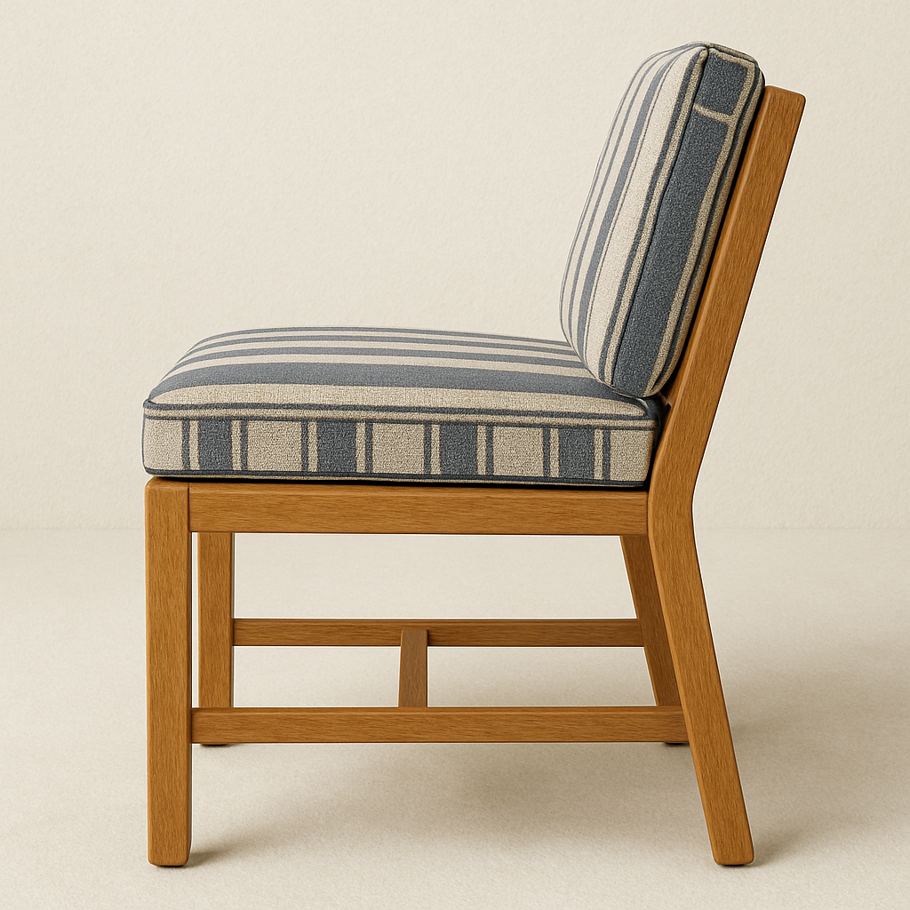 Side profile of an armless outdoor dining chair featuring a teak wood frame and navy-and-beige striped fabric seat and back cushions on a neutral background.