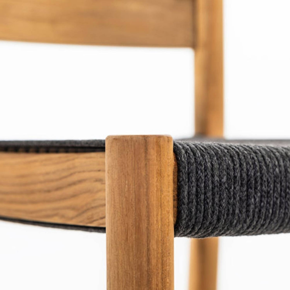 Close-up of a natural teak stool leg and rail with a tightly woven gray fabric-wrapped seat edge, highlighting the wood grain and wrapped seat texture.